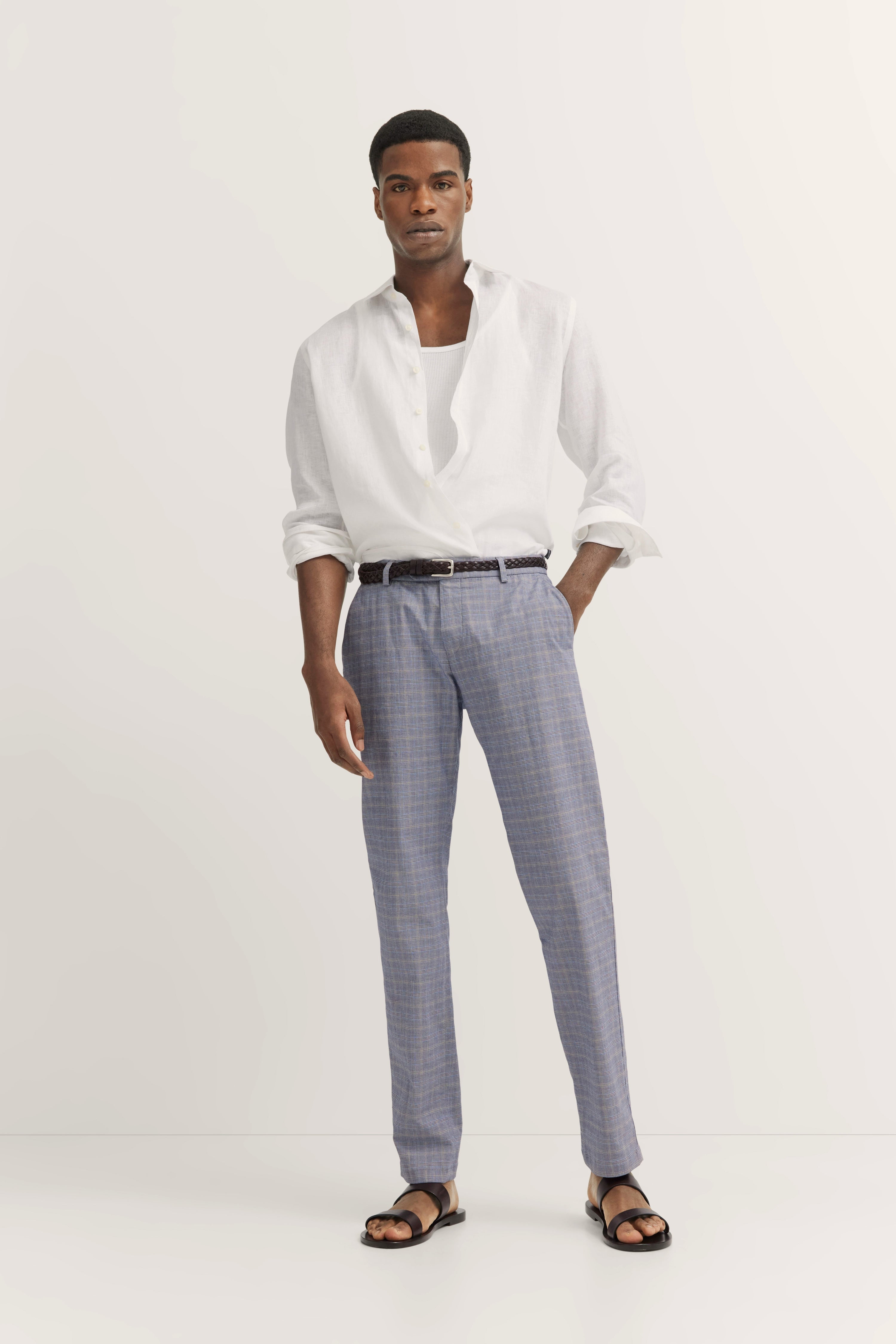 Weiße Hemd und karierte blaue Hose von bugatti, legeres Modelbild, entspanntes Stehen von hinten.