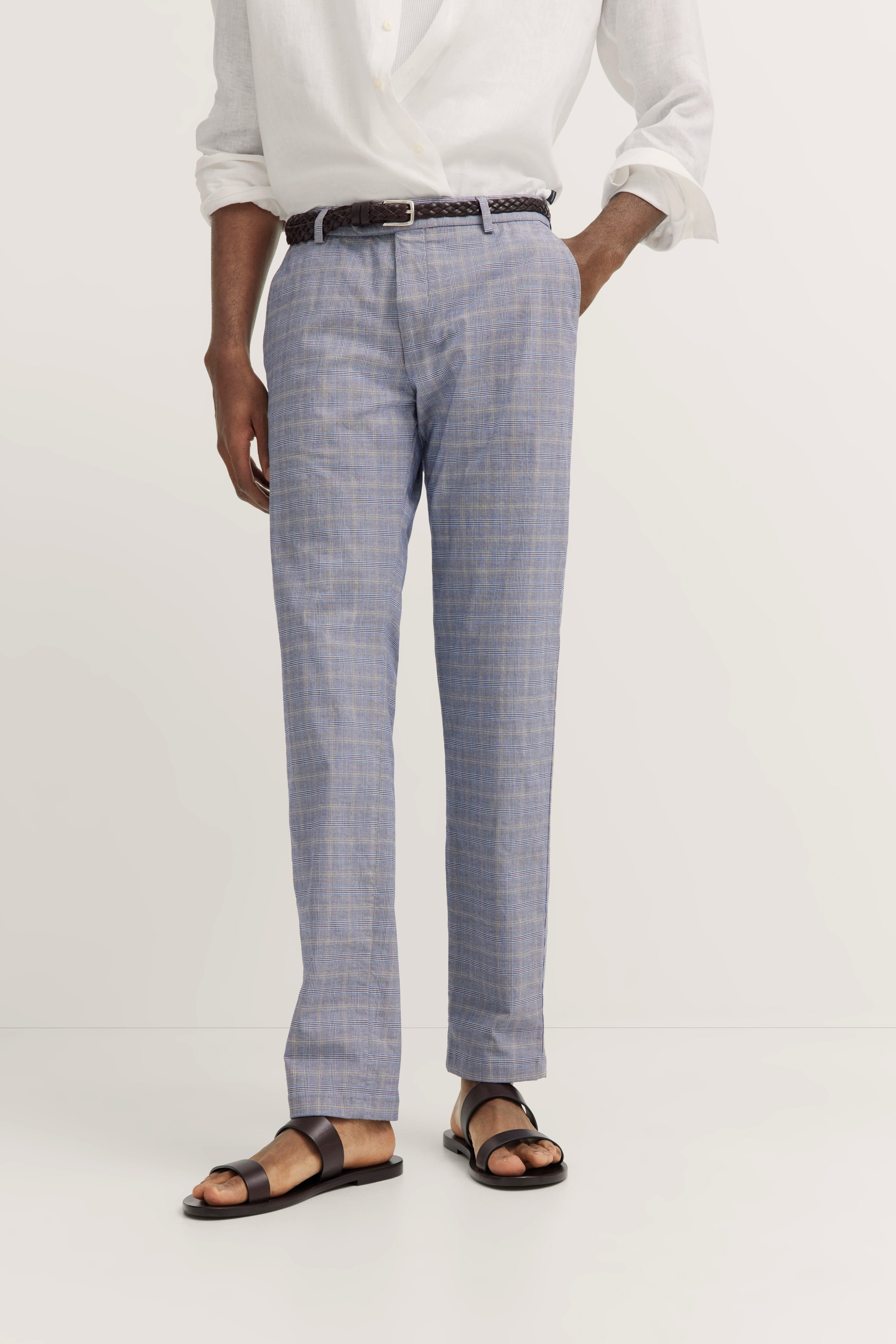 Wit overhemd, blauw geruite broek, zwarte riem, bruine sandalen van bugatti