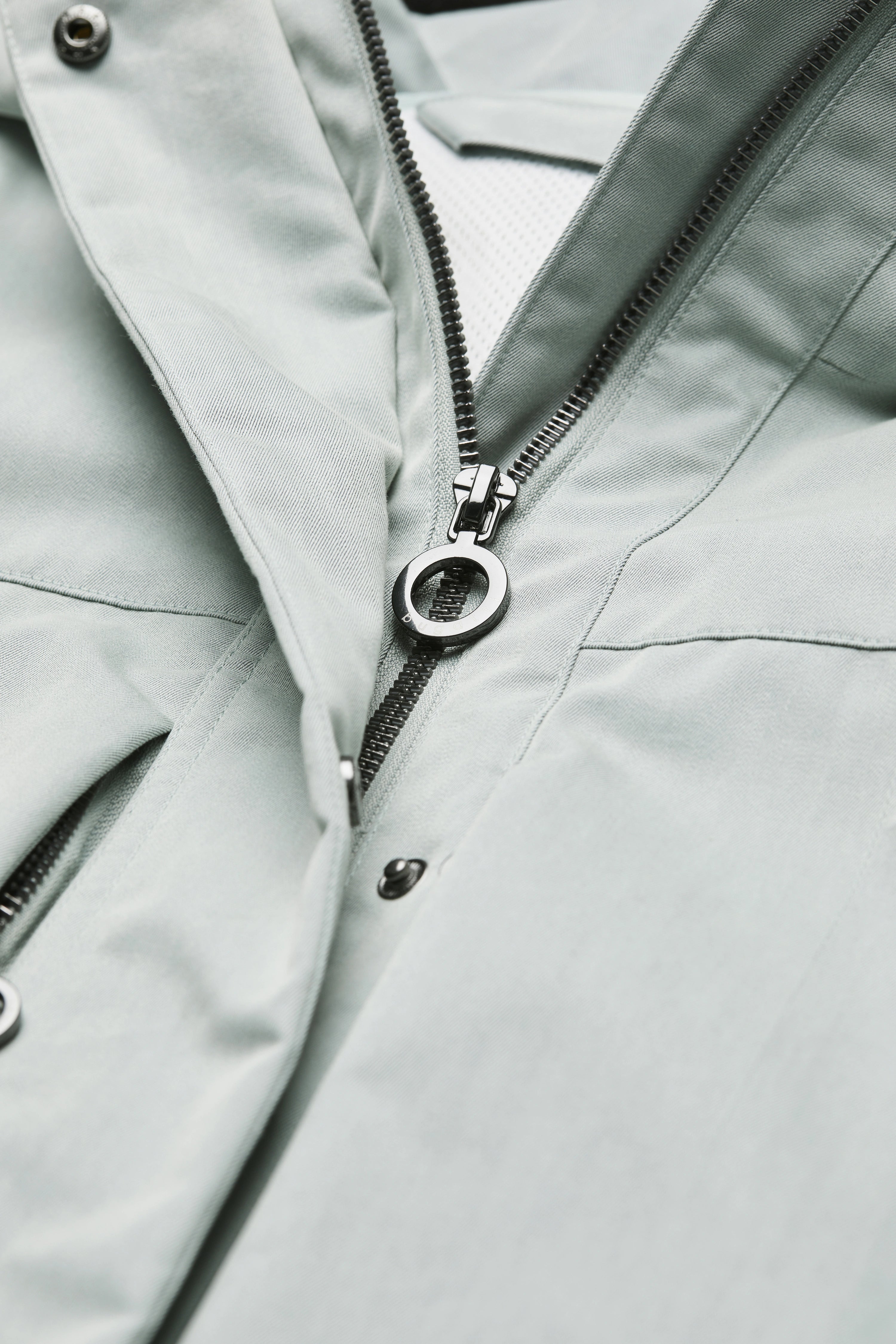 Detailaufnahme einer hellgrauen bugatti-Jacke mit Reißverschluss.