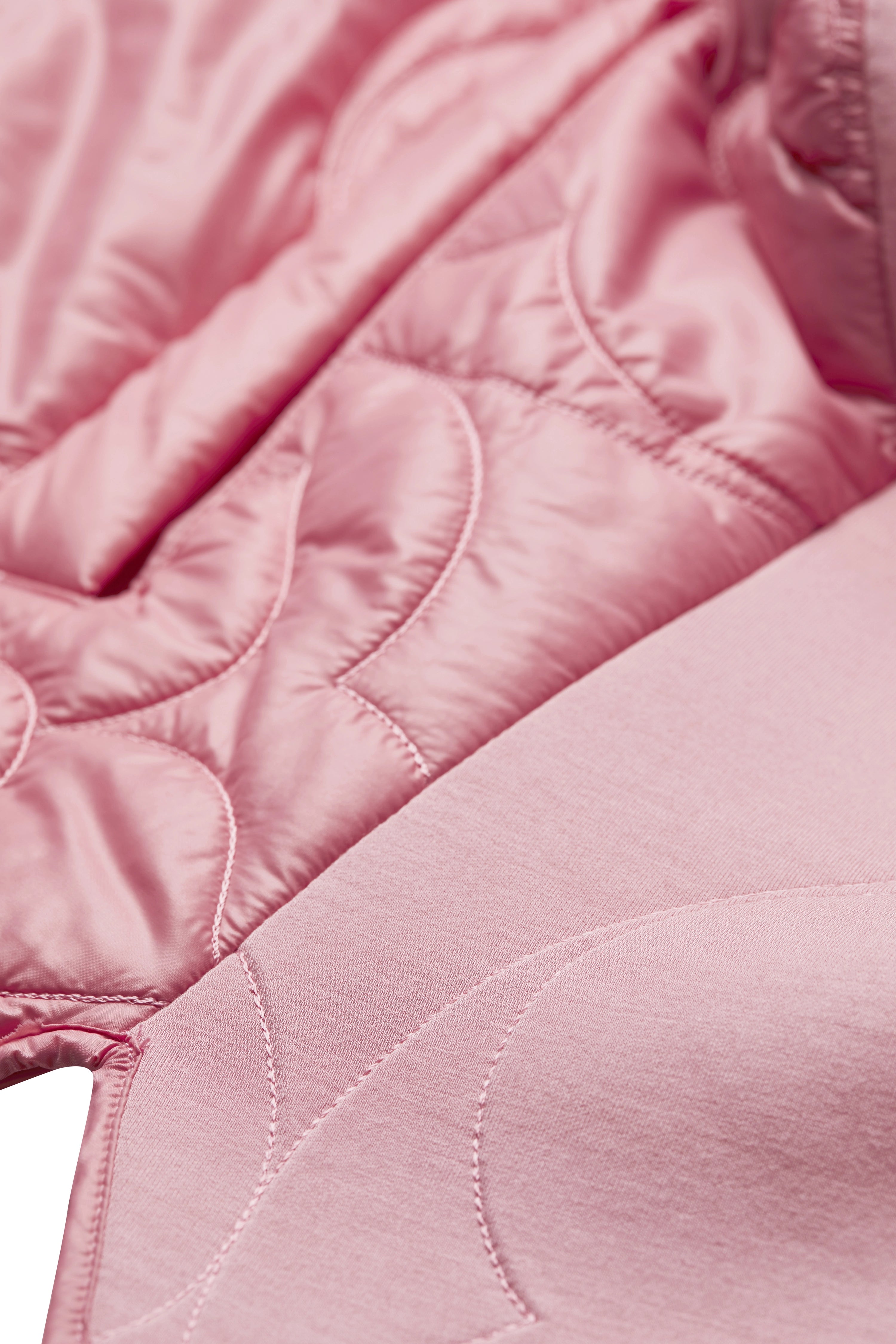 Close-up of pink quilted bugatti jacket, showcasing pattern detail and high-quality material.