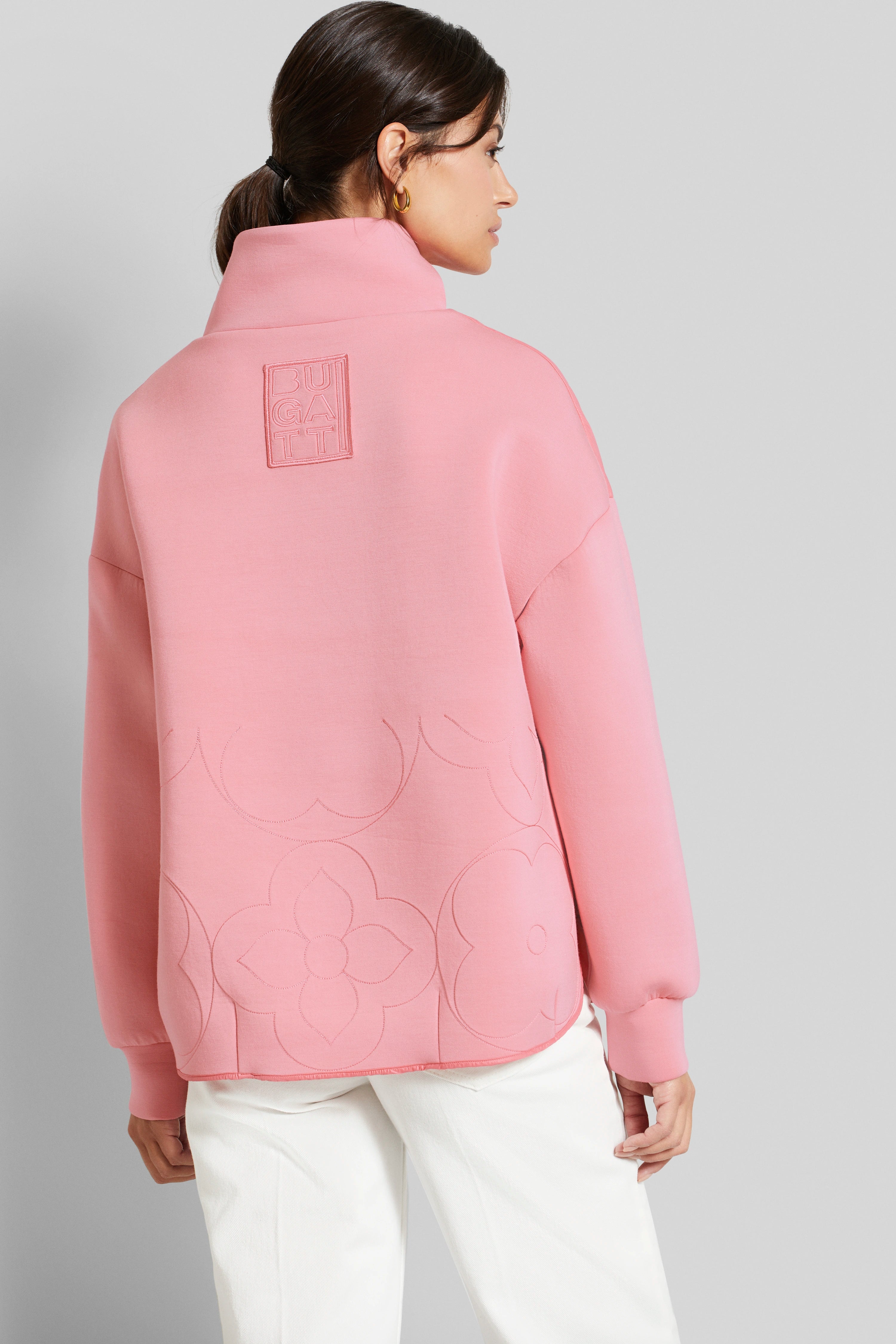 Pink bugatti sweatshirt with floral patterns, model from behind in a relaxed pose.