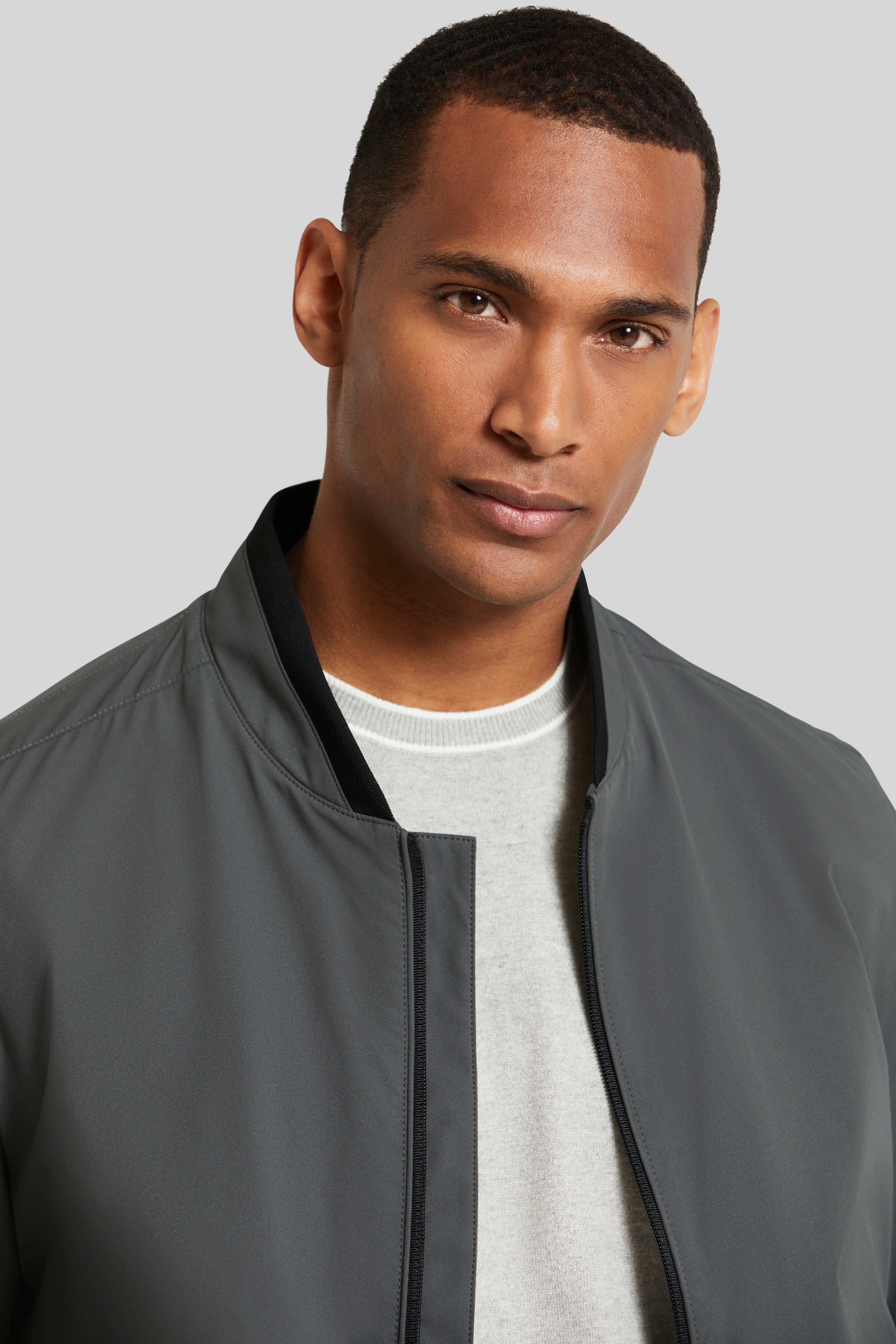 Graue bugatti Jacke, Rückansicht, schlichtes Design mit schwarzem Kragen- und Ärmelabschluss, Büstenbild.