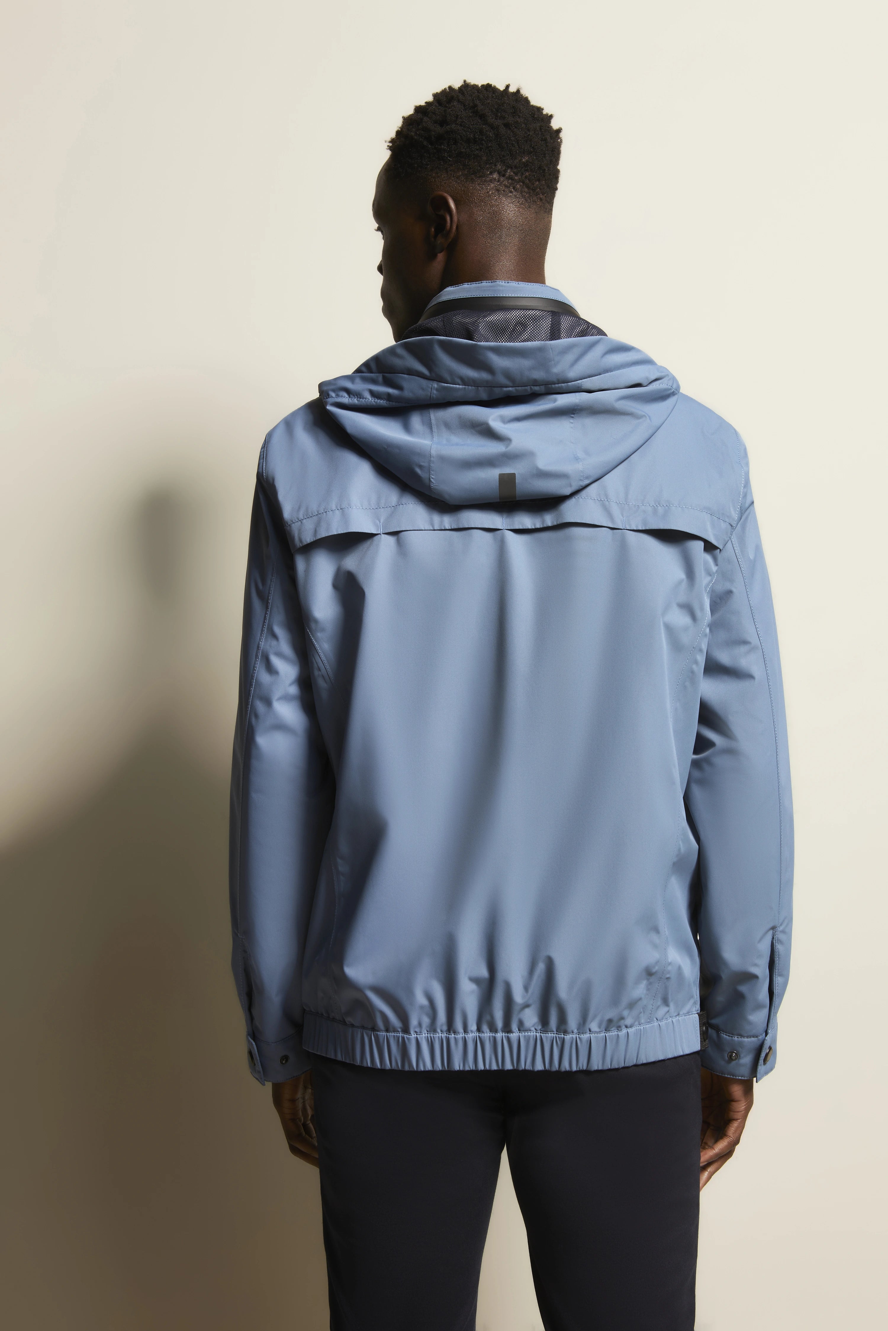 Blau-graue bugatti Jacke, Rückansicht auf Model, entspannter Stand, legerer Stil.