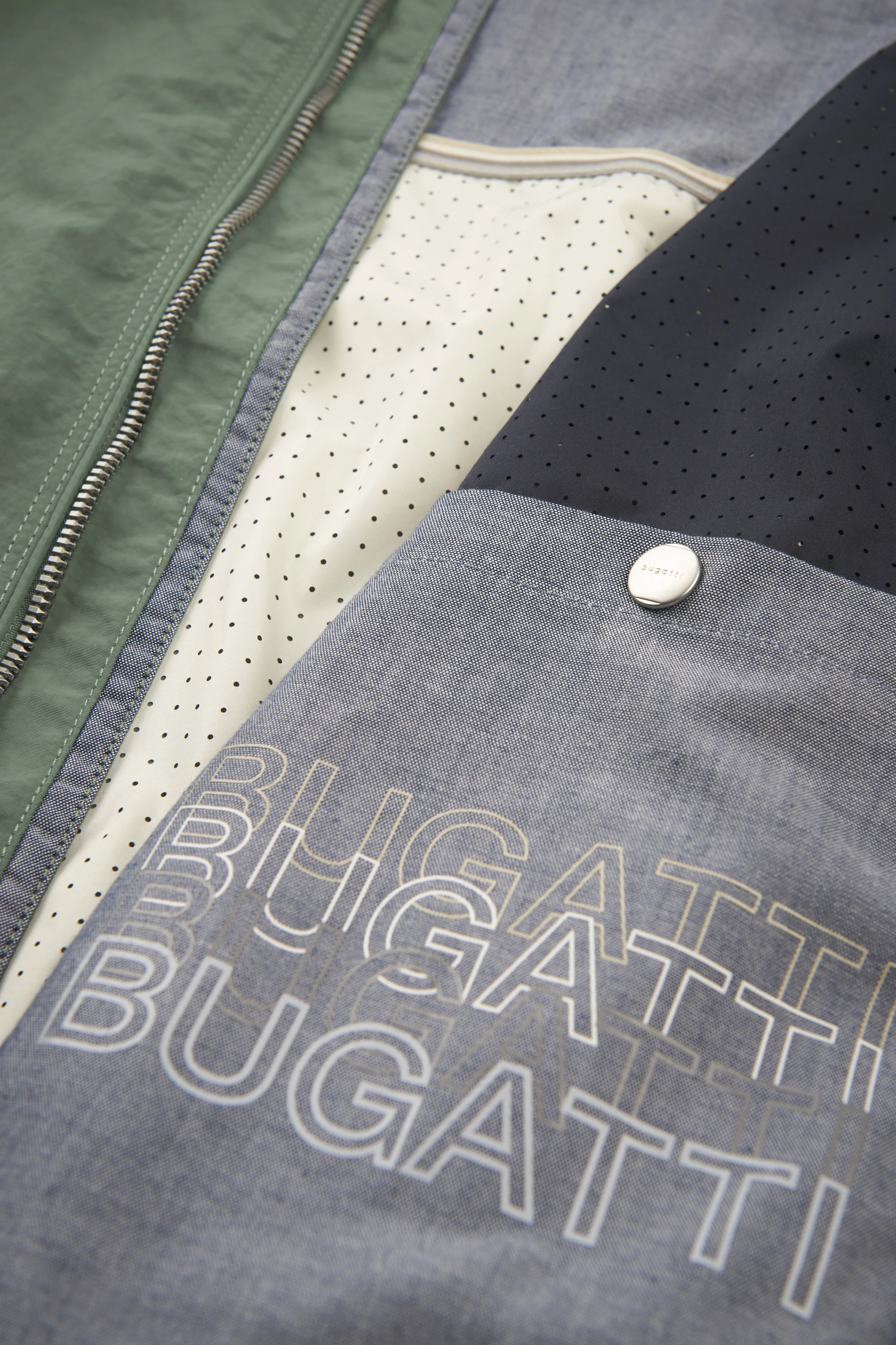 Green and blue bugatti jacket lining with polka dot pattern and logo, close-up.