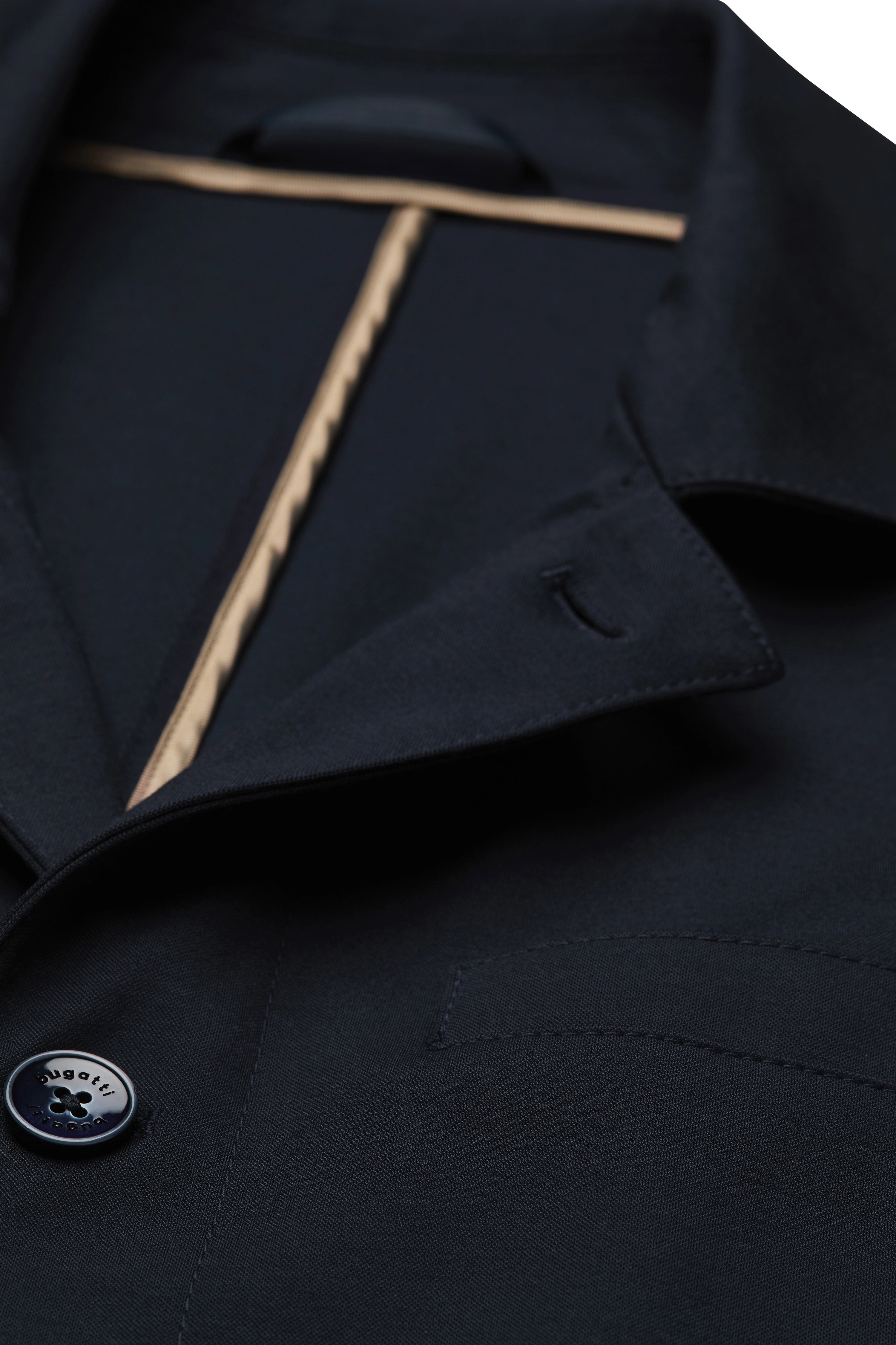 bugatti model: Man in navy coat and beige shirt, gazing sideways, embodying elegance and Italian-inspired style.