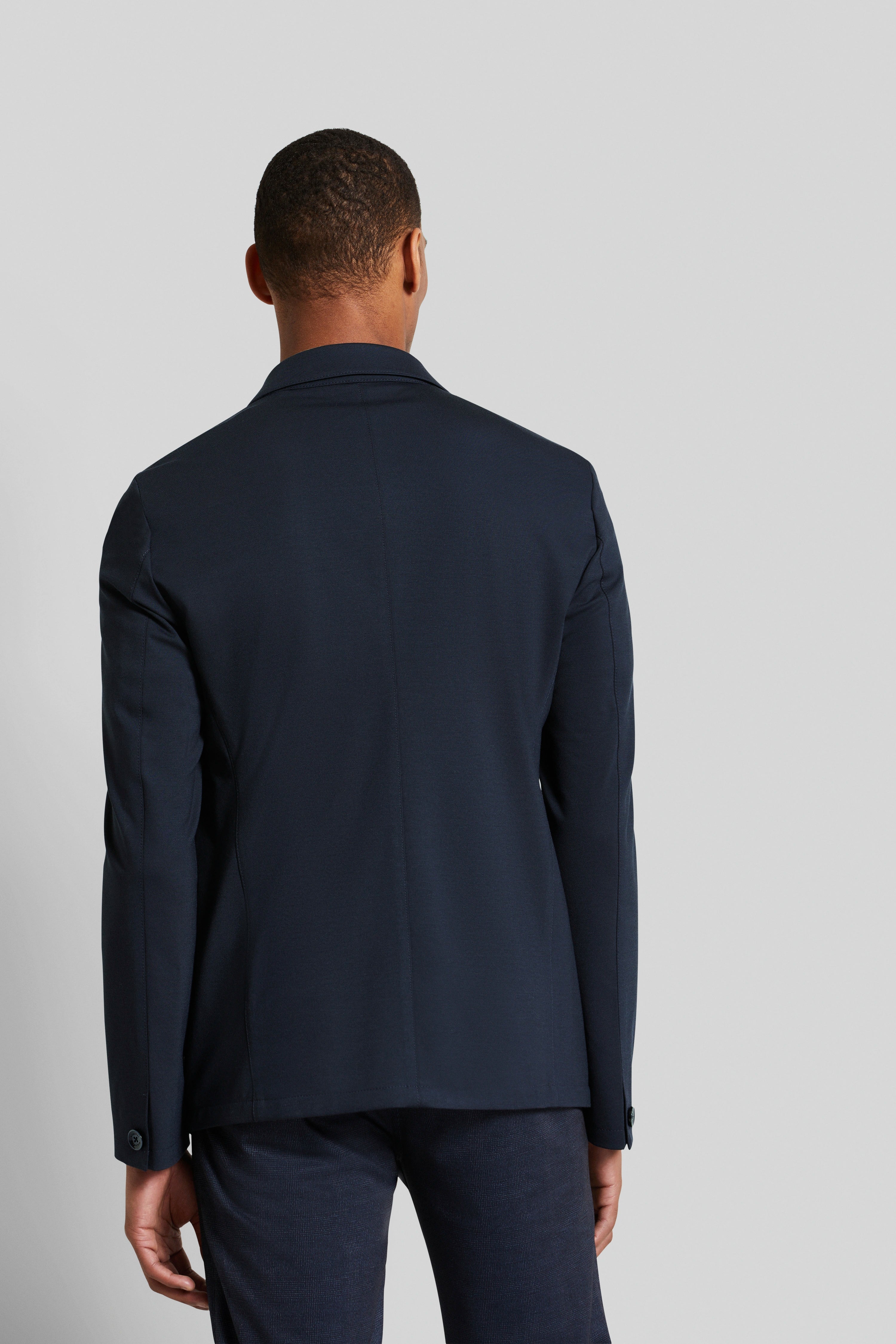 Rear view of model in a dark blue bugatti suit.