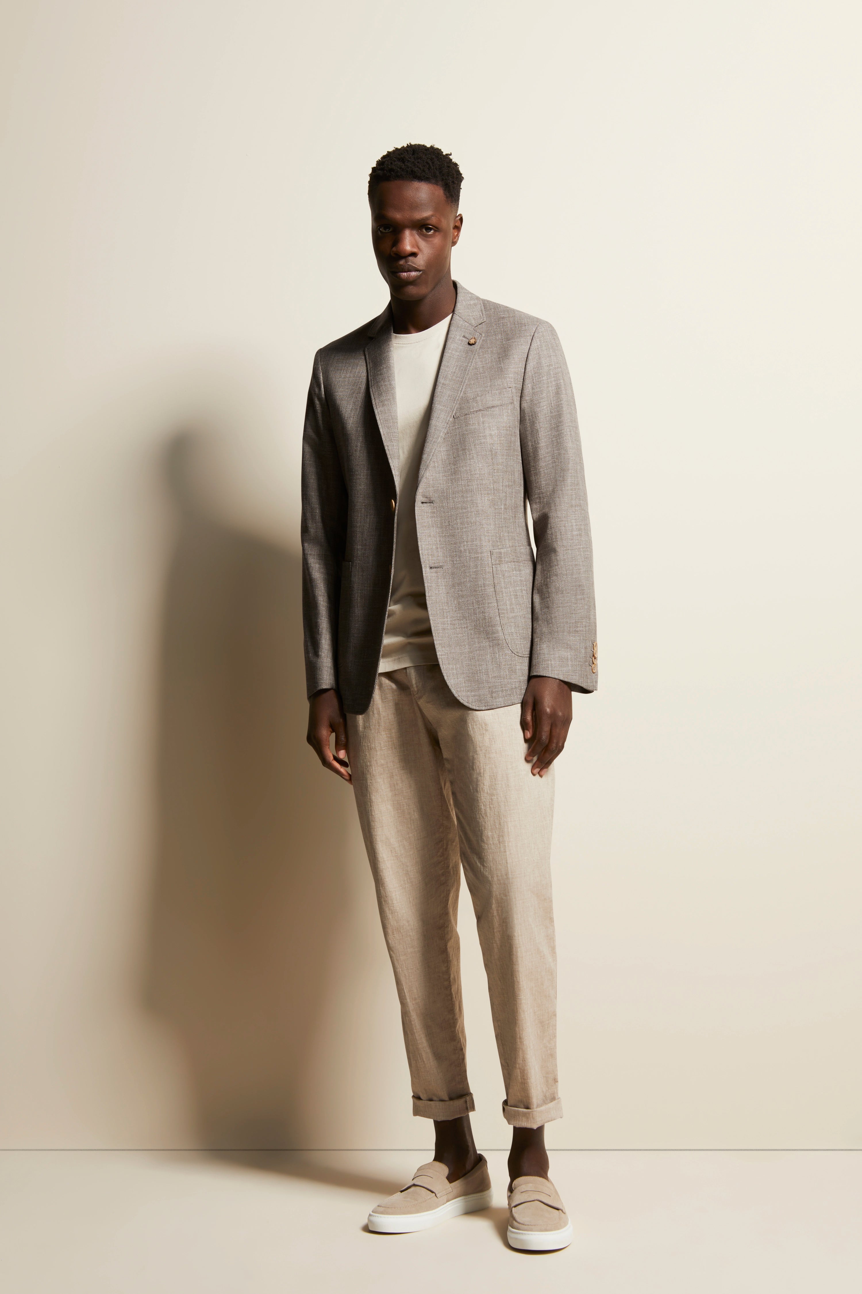 Graues Sakko, helles Shirt, beige Hose