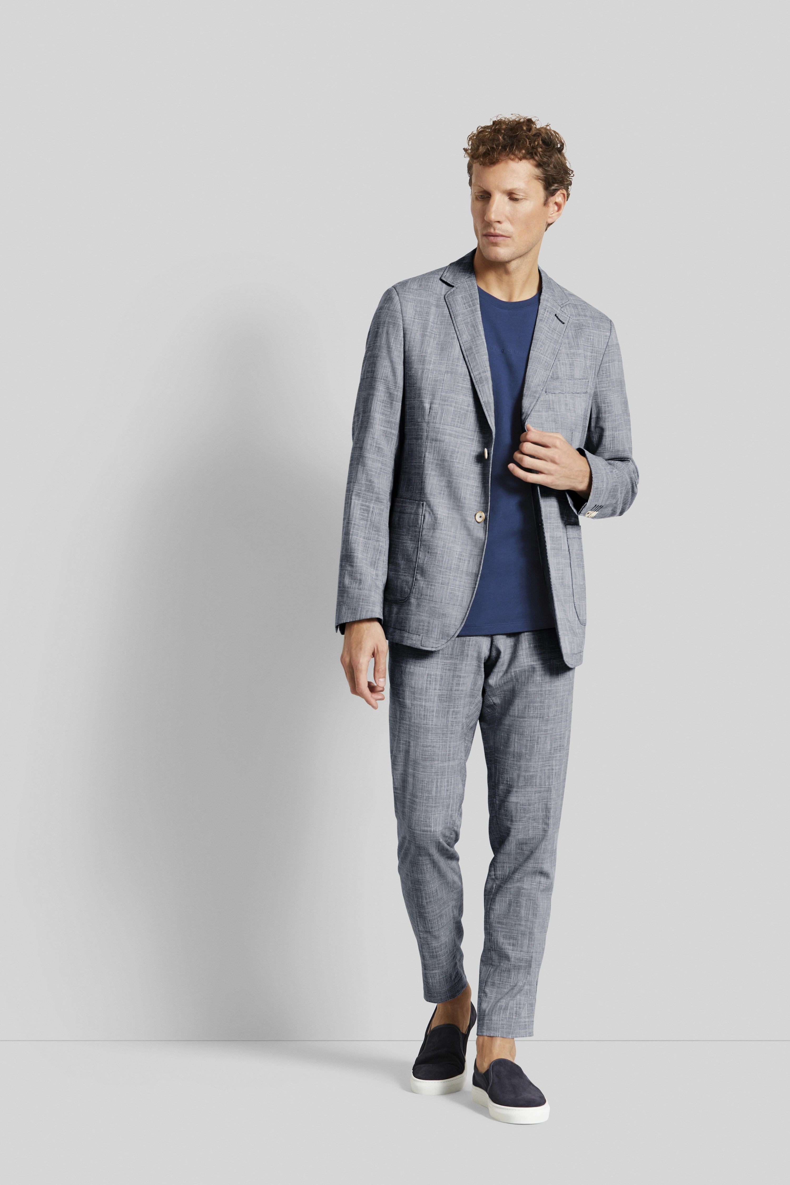 Elegant model shot: Grey suit with blue shirt, relaxed pose. bugatti style and sophistication.
