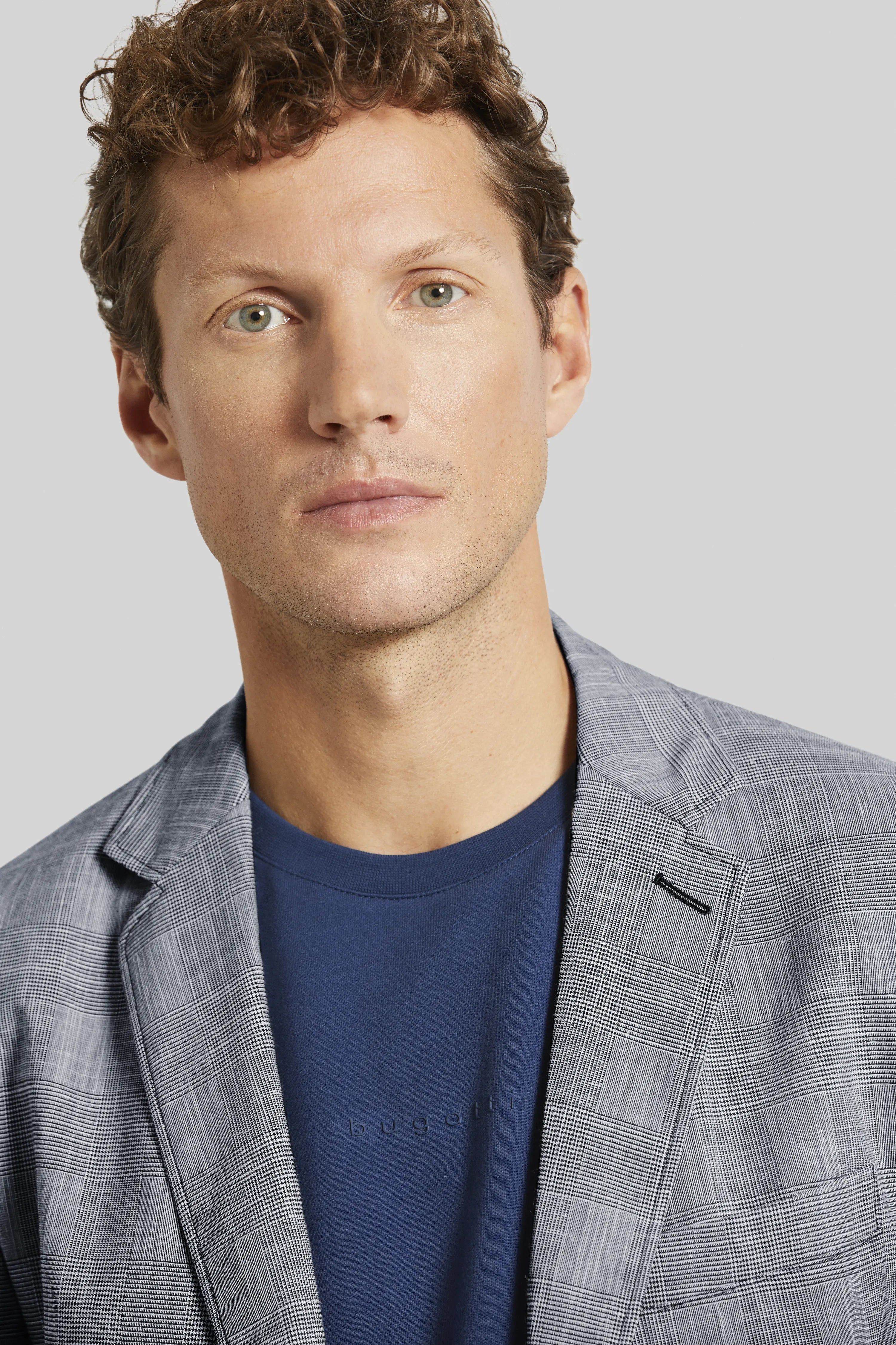 Gray plaid blazer and blue shirt by bugatti, bust view.