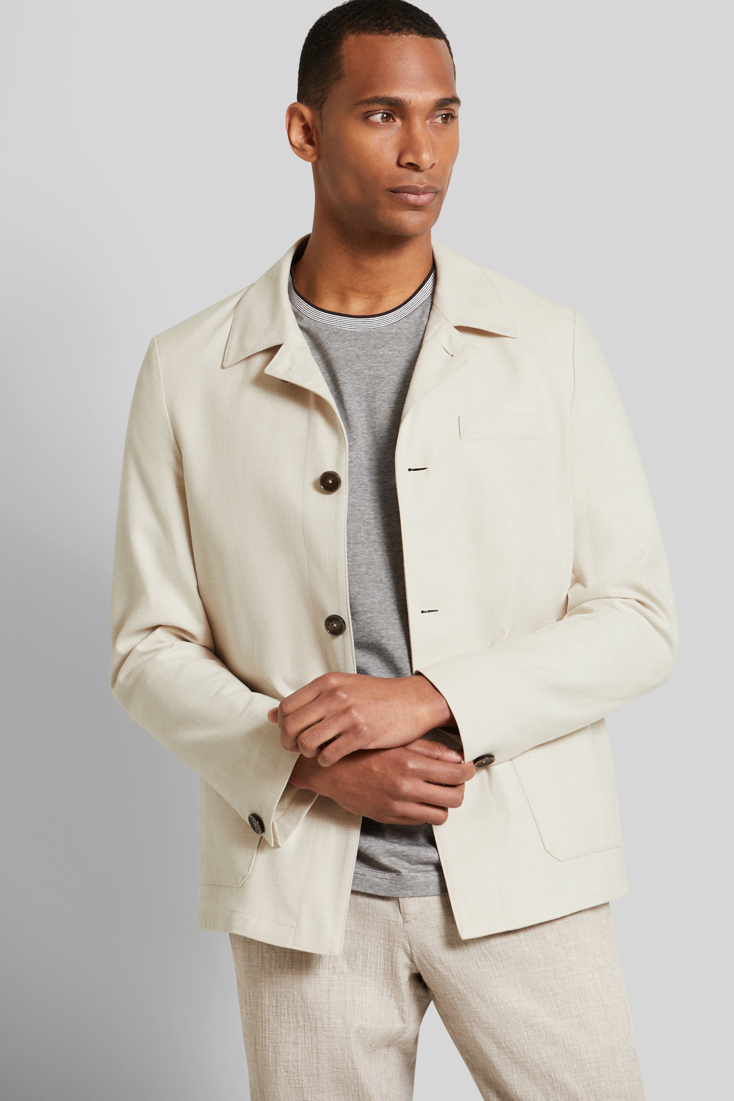 Model in beigem bugatti-Sakko, graues Shirt, beige Hose