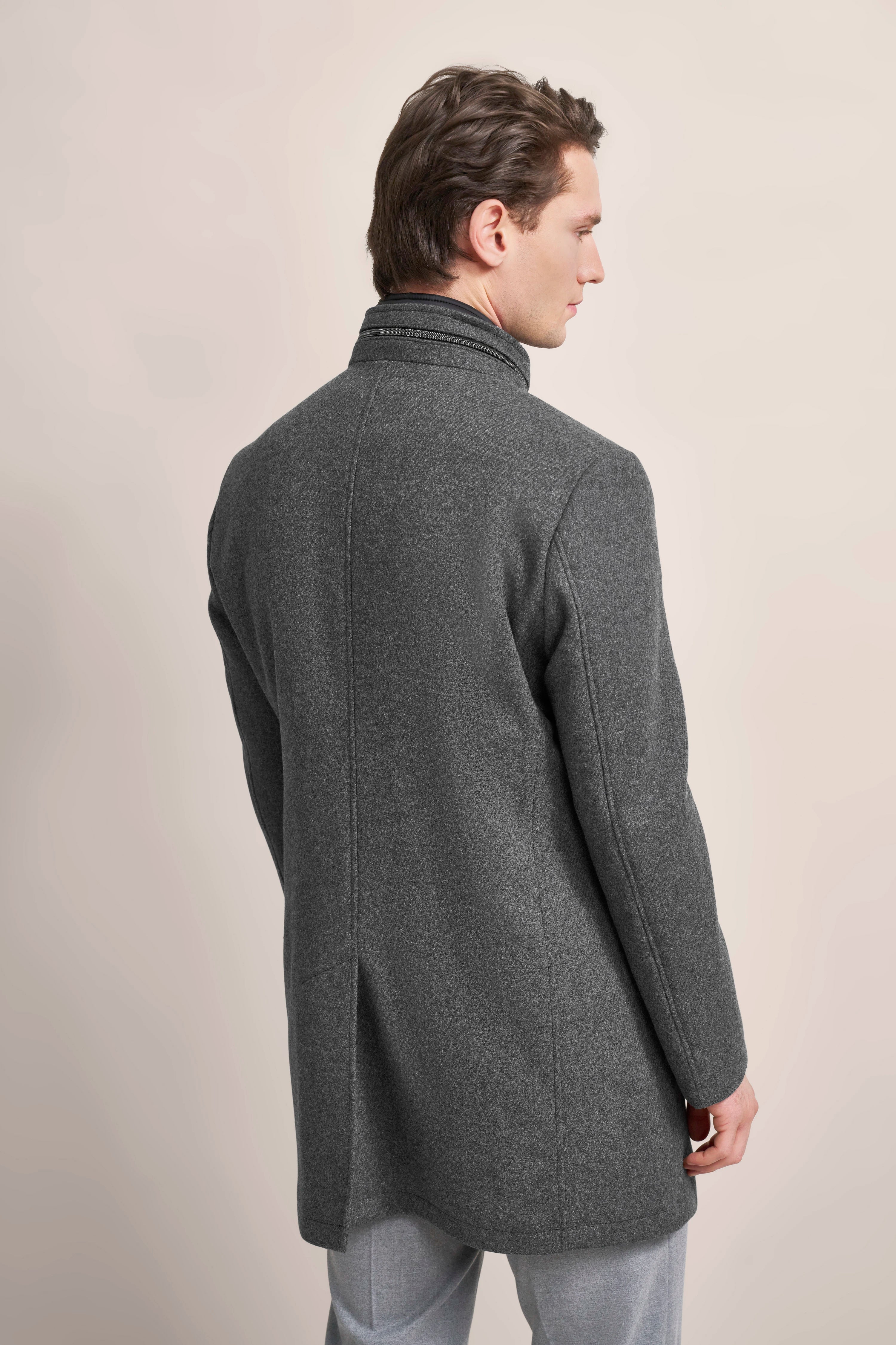 Grey bugatti coat, back view model, elegant design, worn with grey trousers.