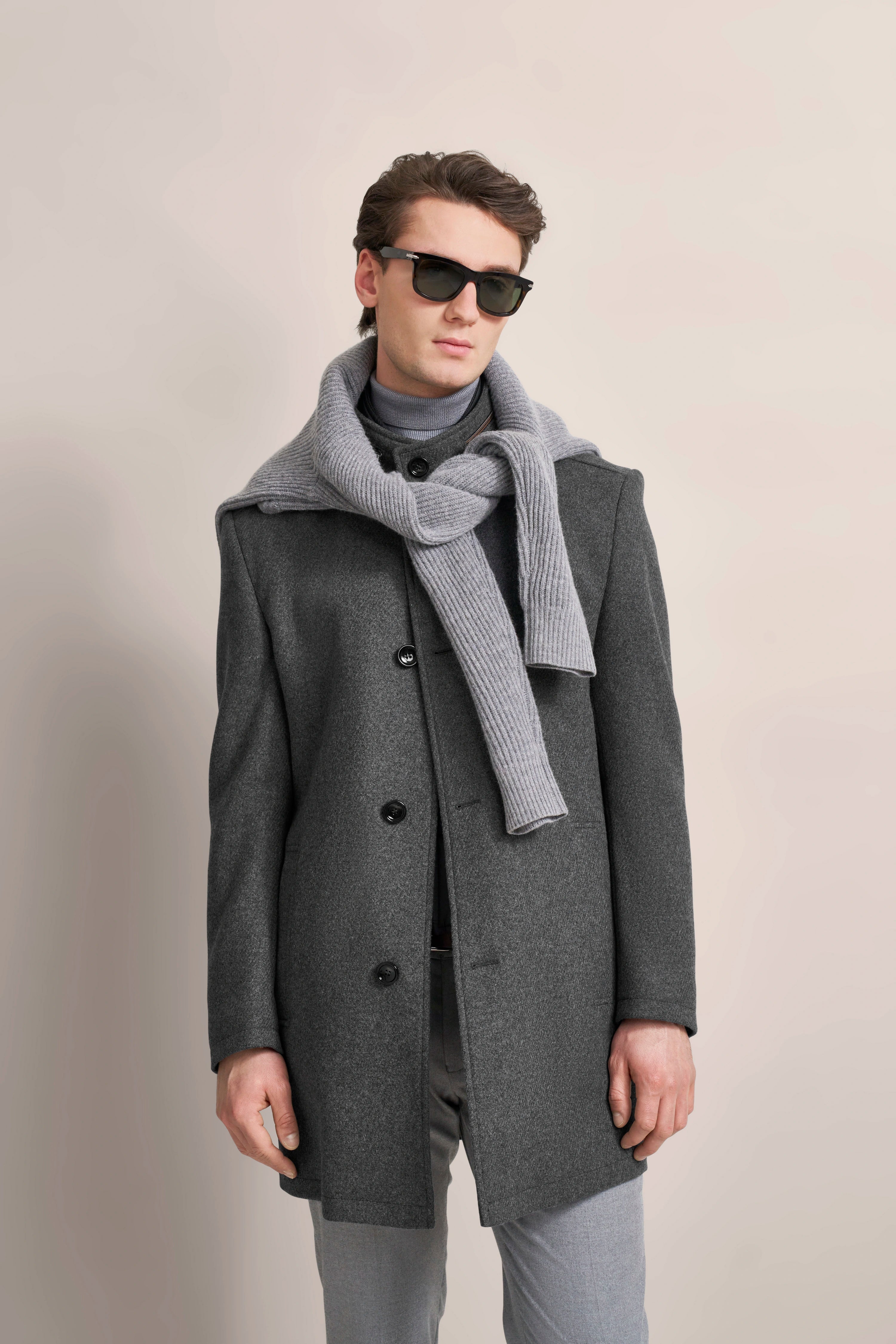 Gray bugatti coat with scarf, model posing relaxed.