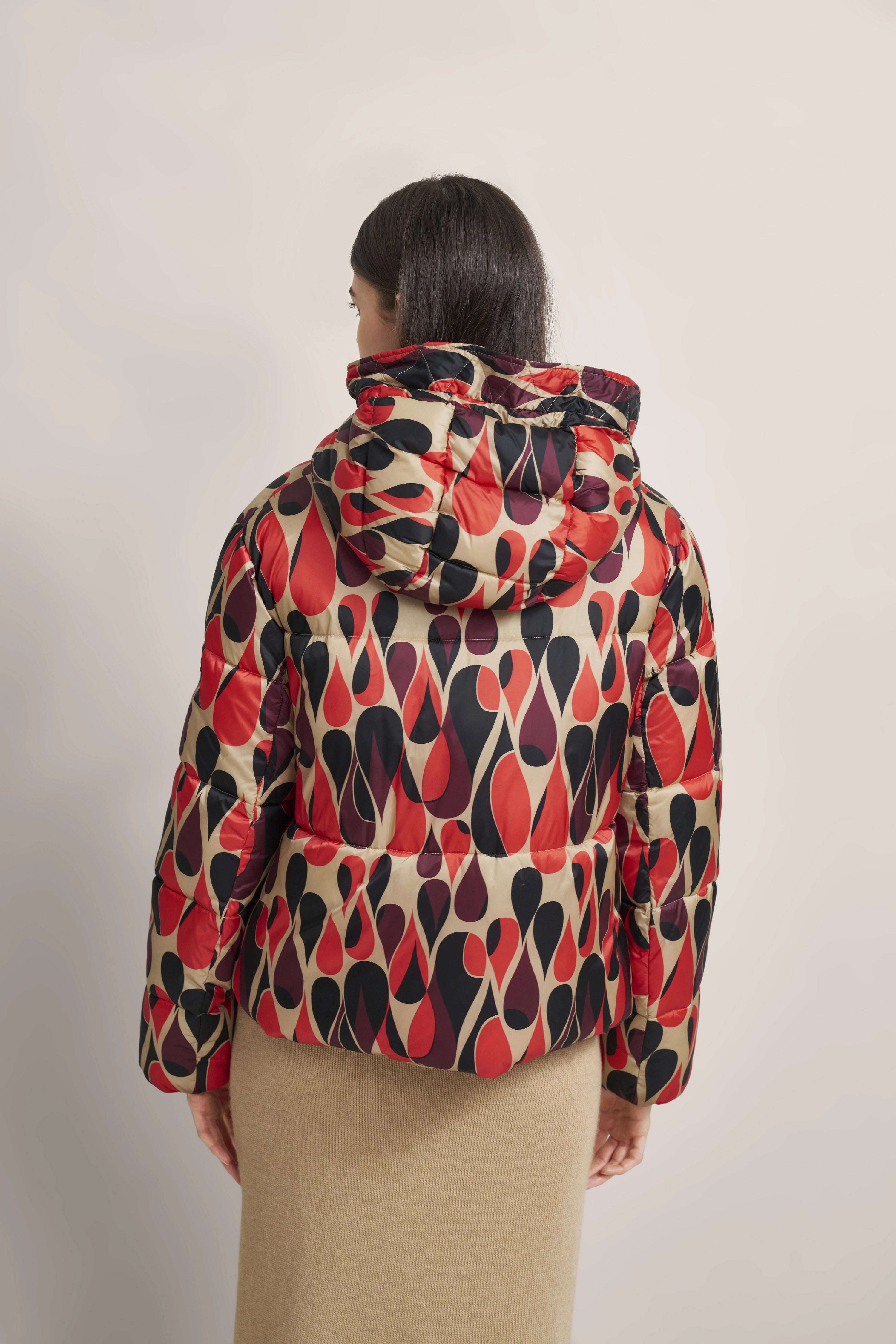 Bunte bugatti Jacke mit abstraktem Muster, Model von hinten, beige Rock, entspannter Stil.