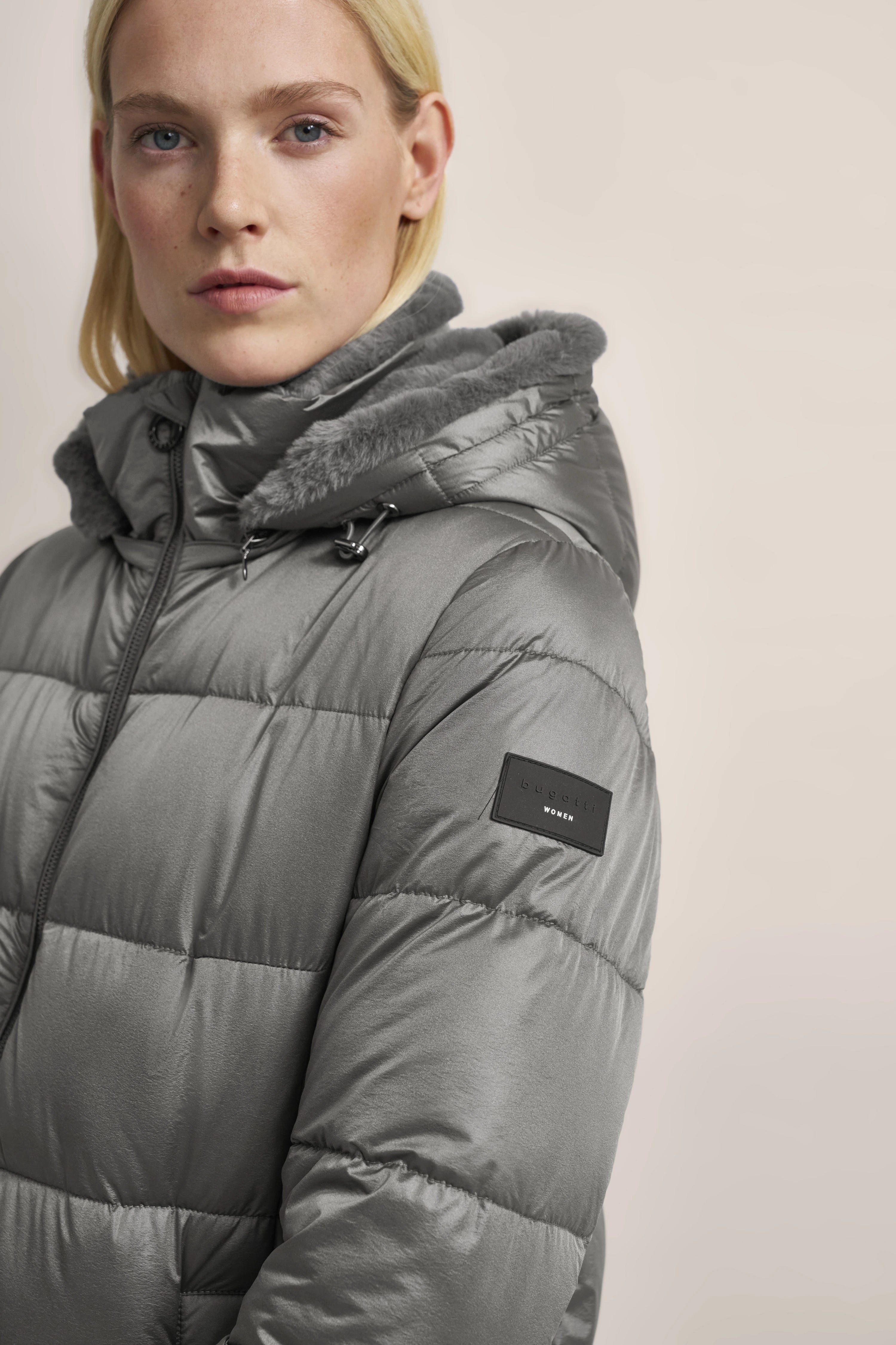 Gray bugatti down jacket with hood, model in relaxed pose.