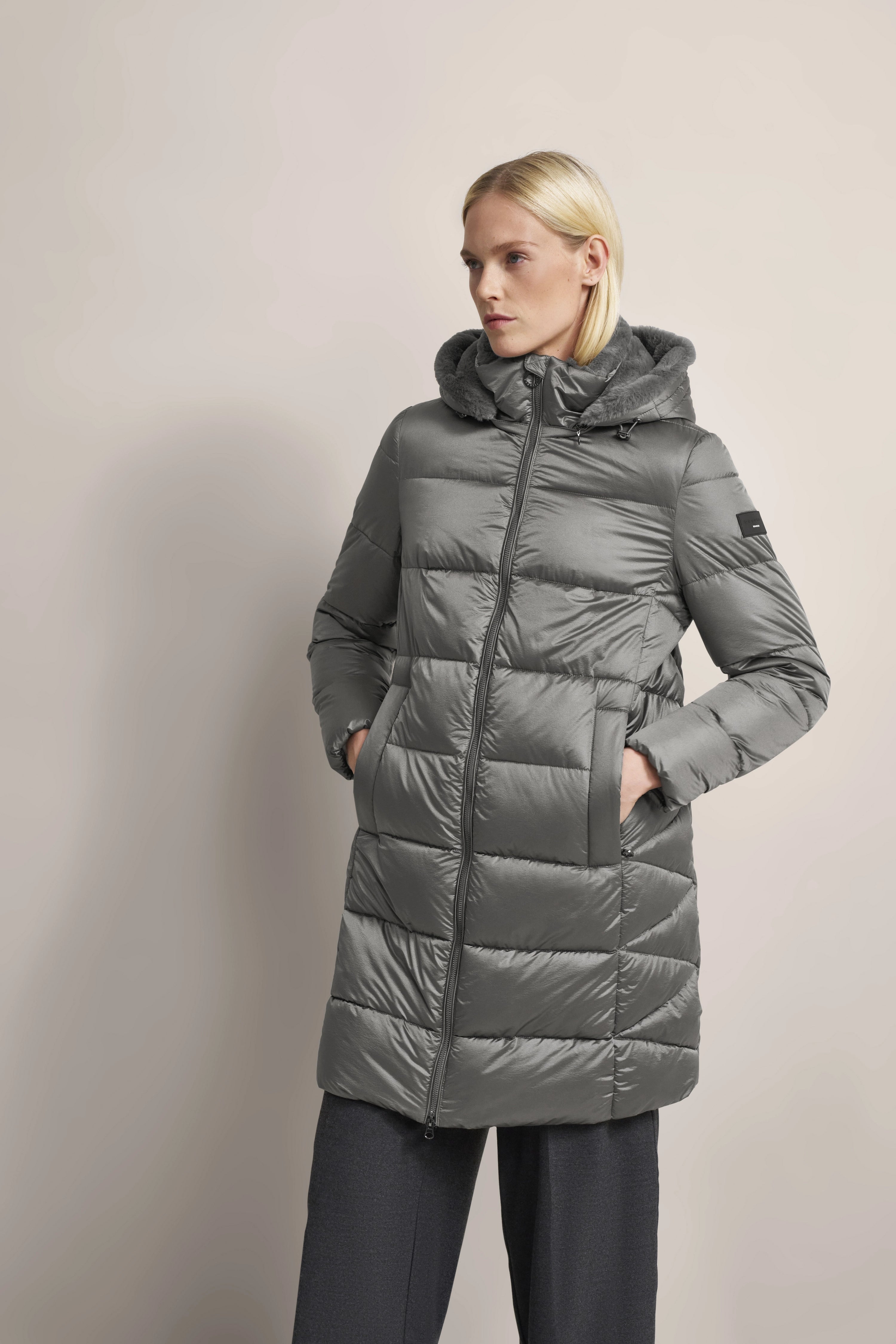 Gray bugatti down jacket with hood, model posing casually, hands in pockets.
