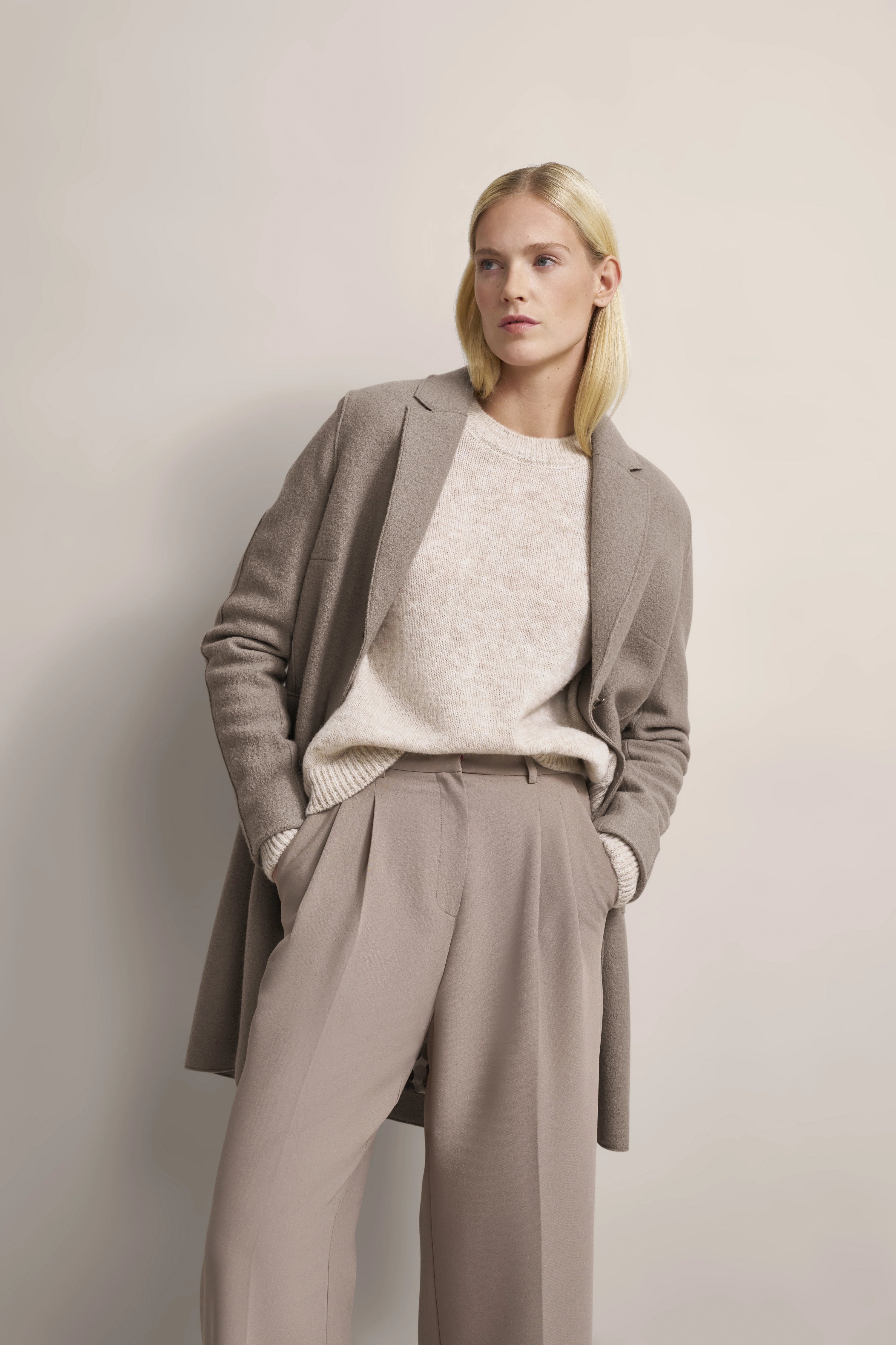 Elegantes Model-Outfit: Beige Mantel, cremefarbener Pullover, beige Hose