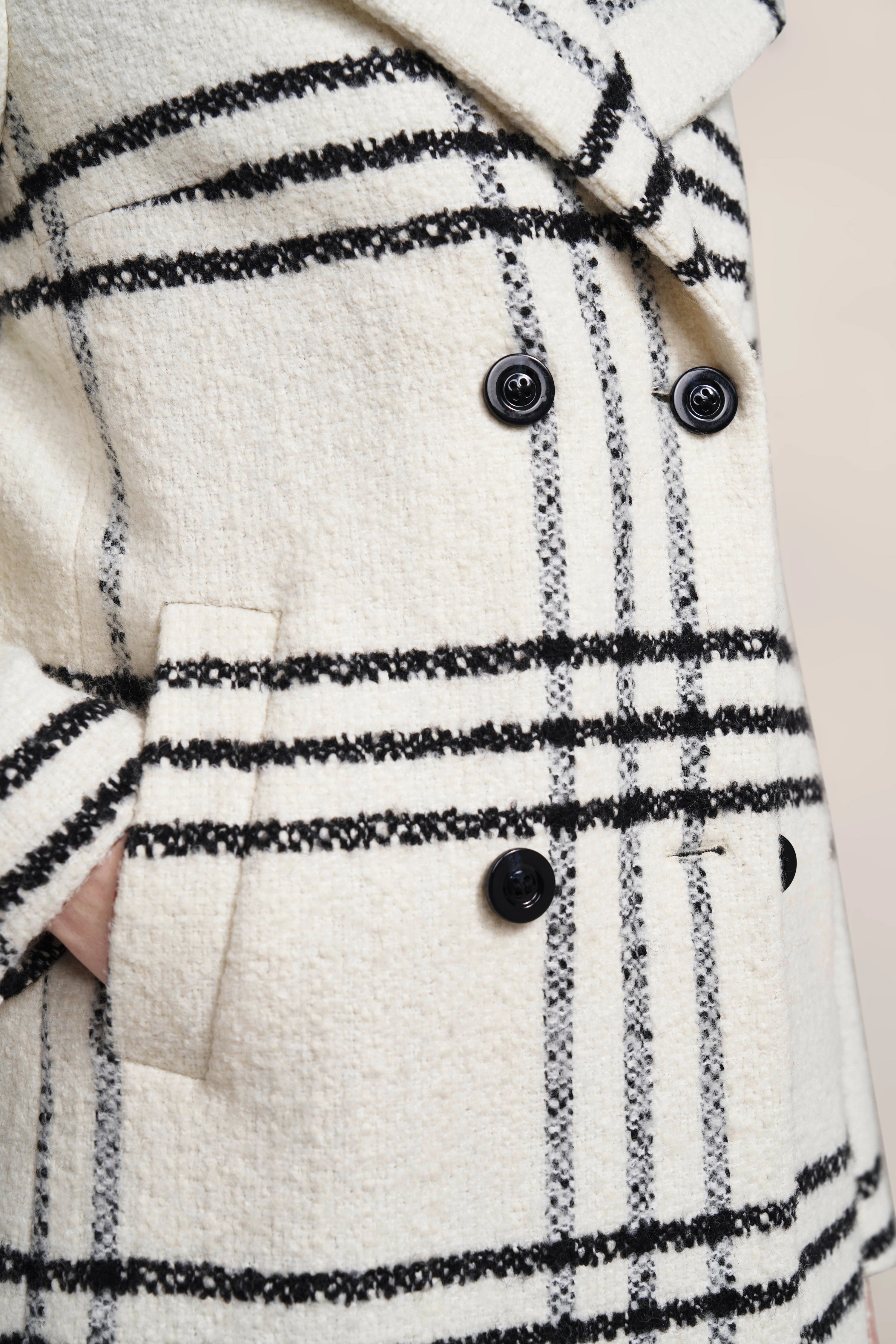 Weißer bugatti Mantel mit schwarzem Karomuster und Knöpfen, Detailansicht.