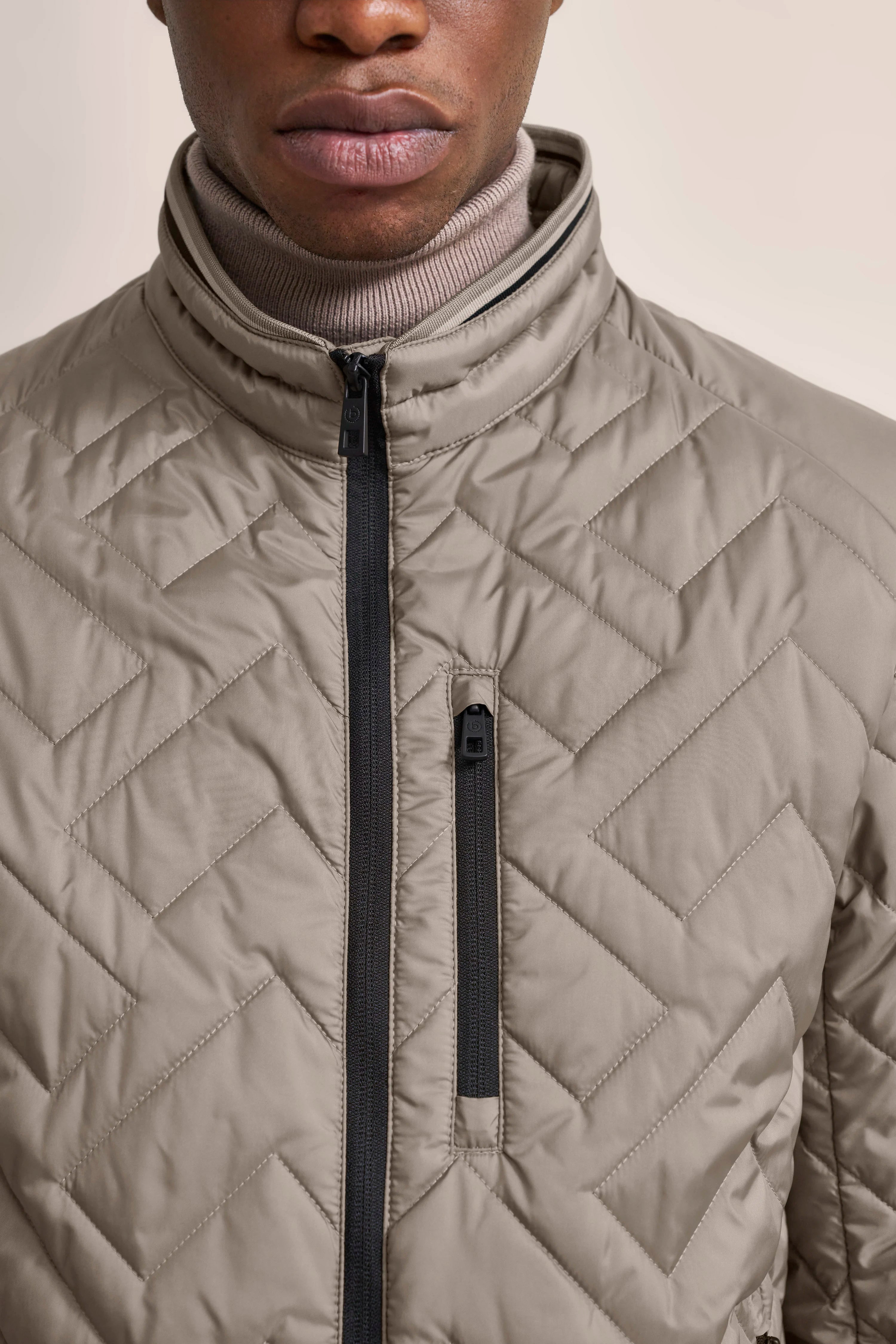 Steppjacke in Beige mit Zickzack-Muster, hoher Kragen, Modelbild von bugatti.