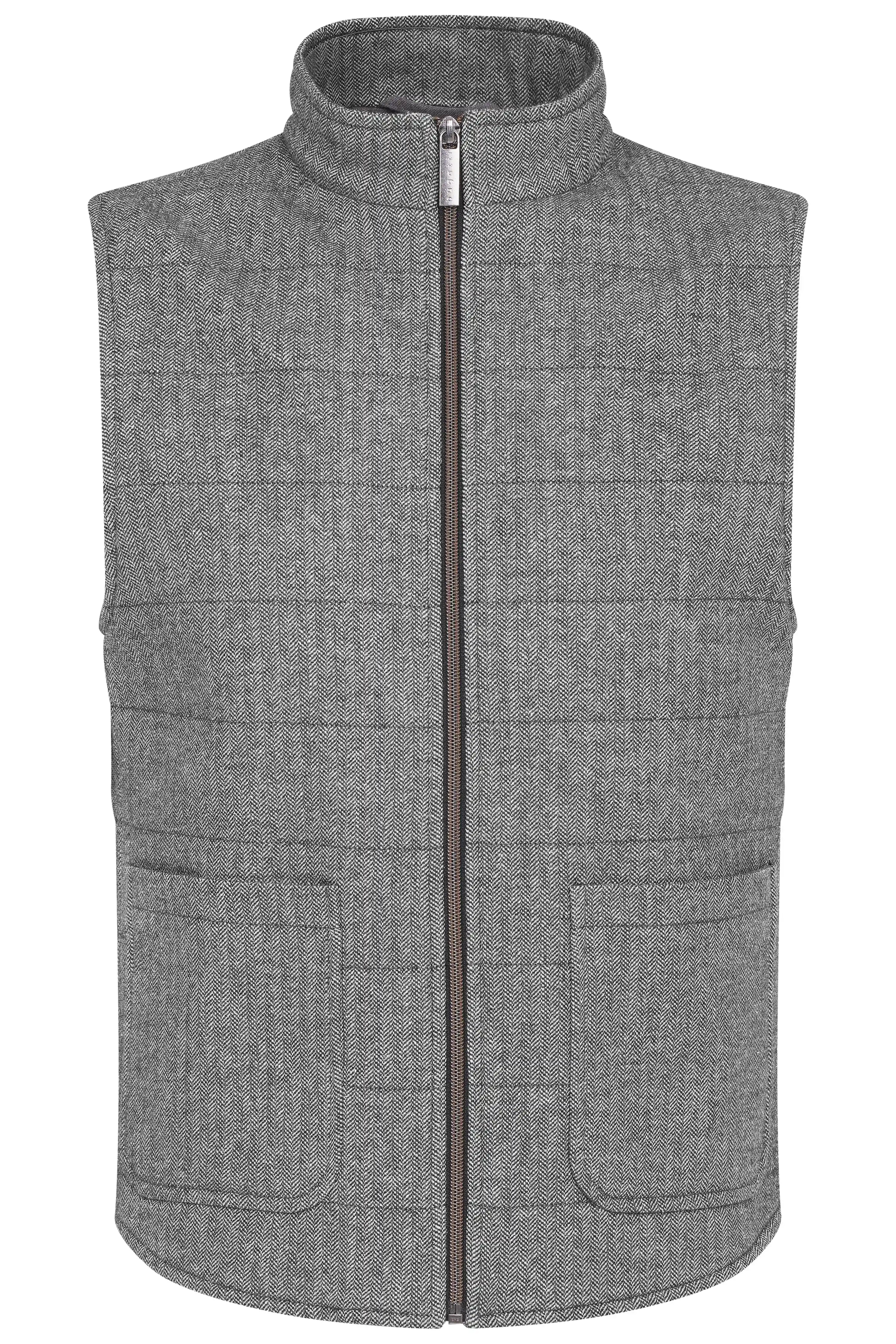 Model in grauer Weste, schwarzem Rollkragenpullover und grauer Hose, steht entspannt.