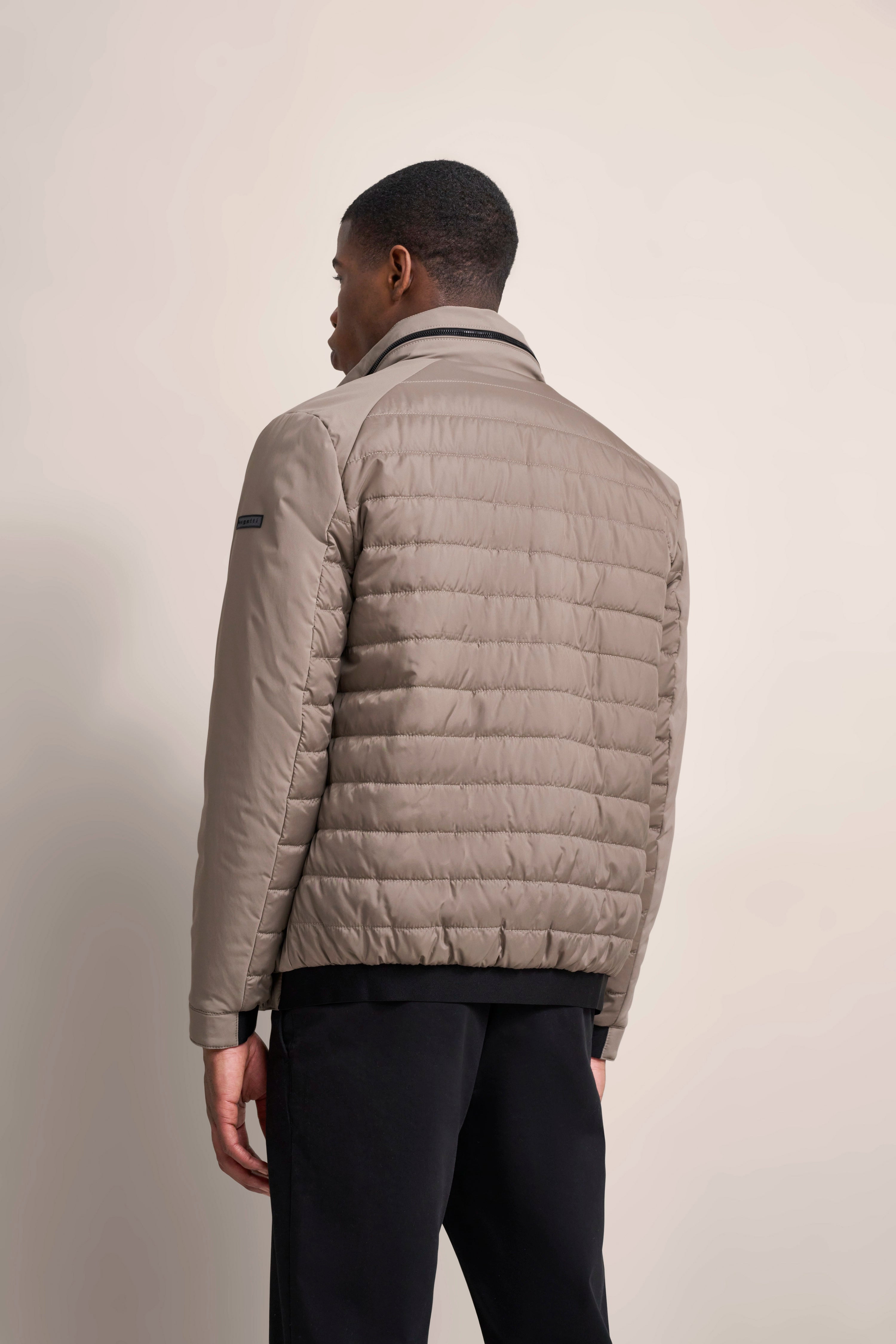 bugatti beige quilted jacket, model rear view, casual stance.