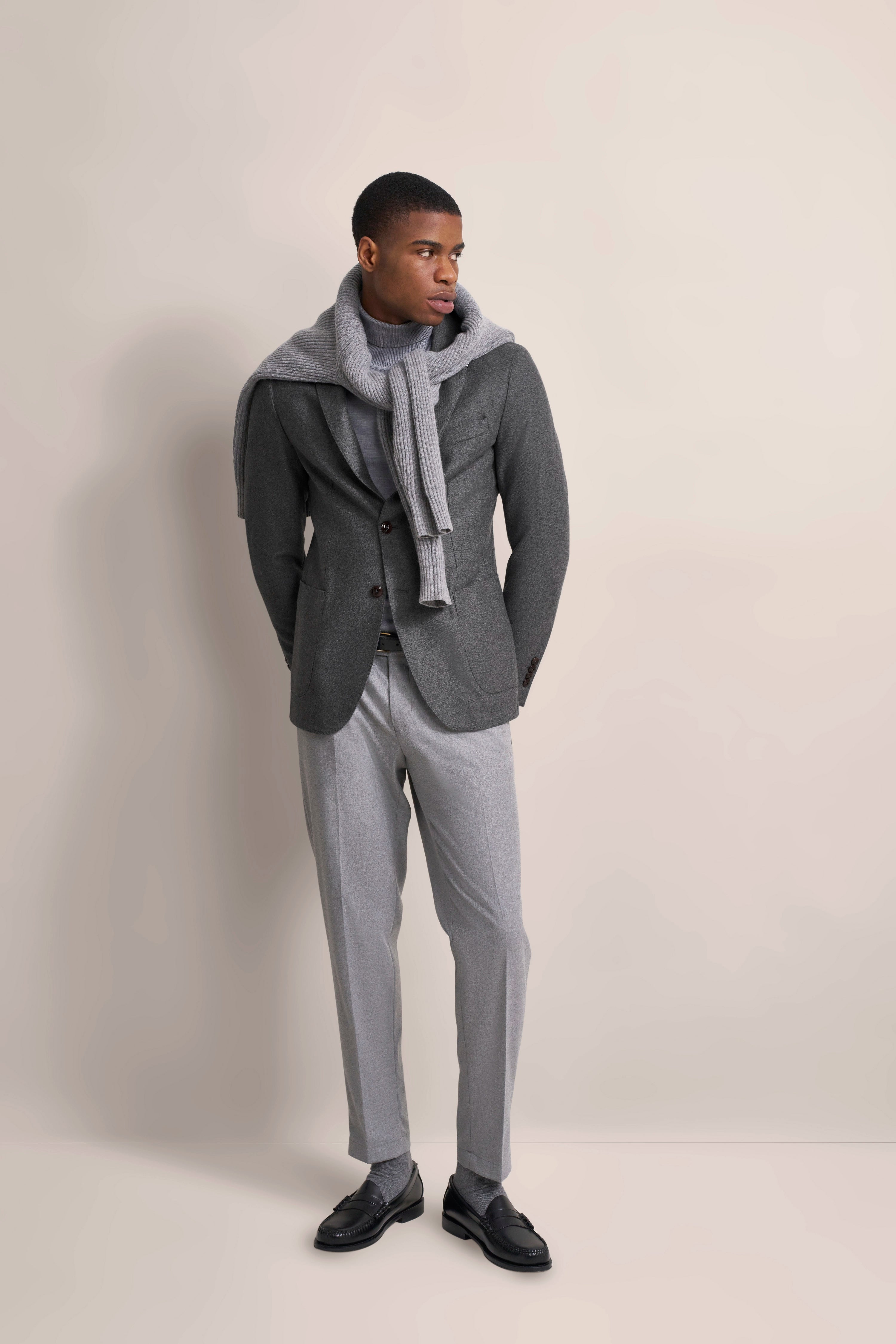 Grauer bugatti Anzug mit Schal, legeres Modelbild, lässige Pose.