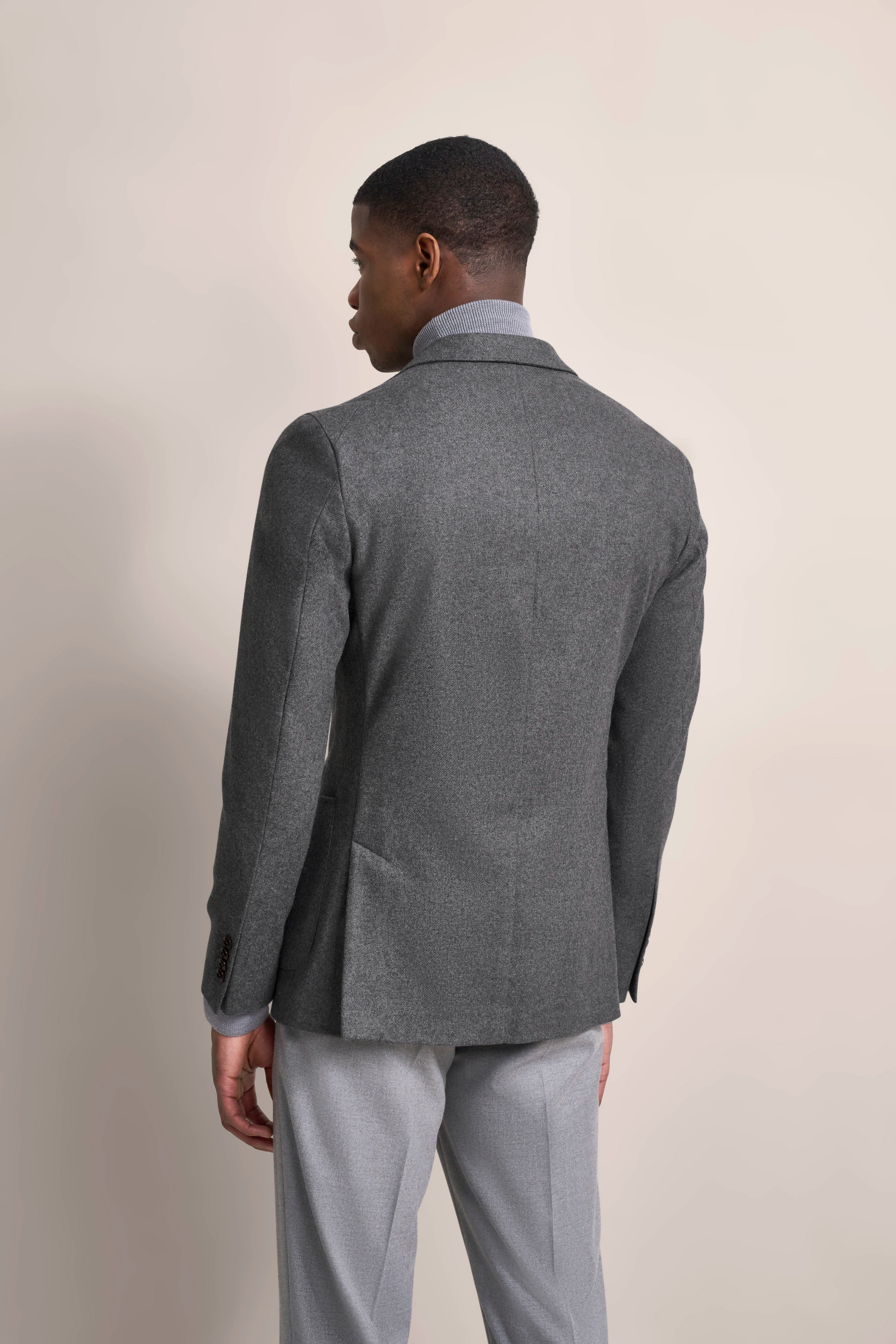 Grauer bugatti-Anzug von hinten, Model in legerer Pose.