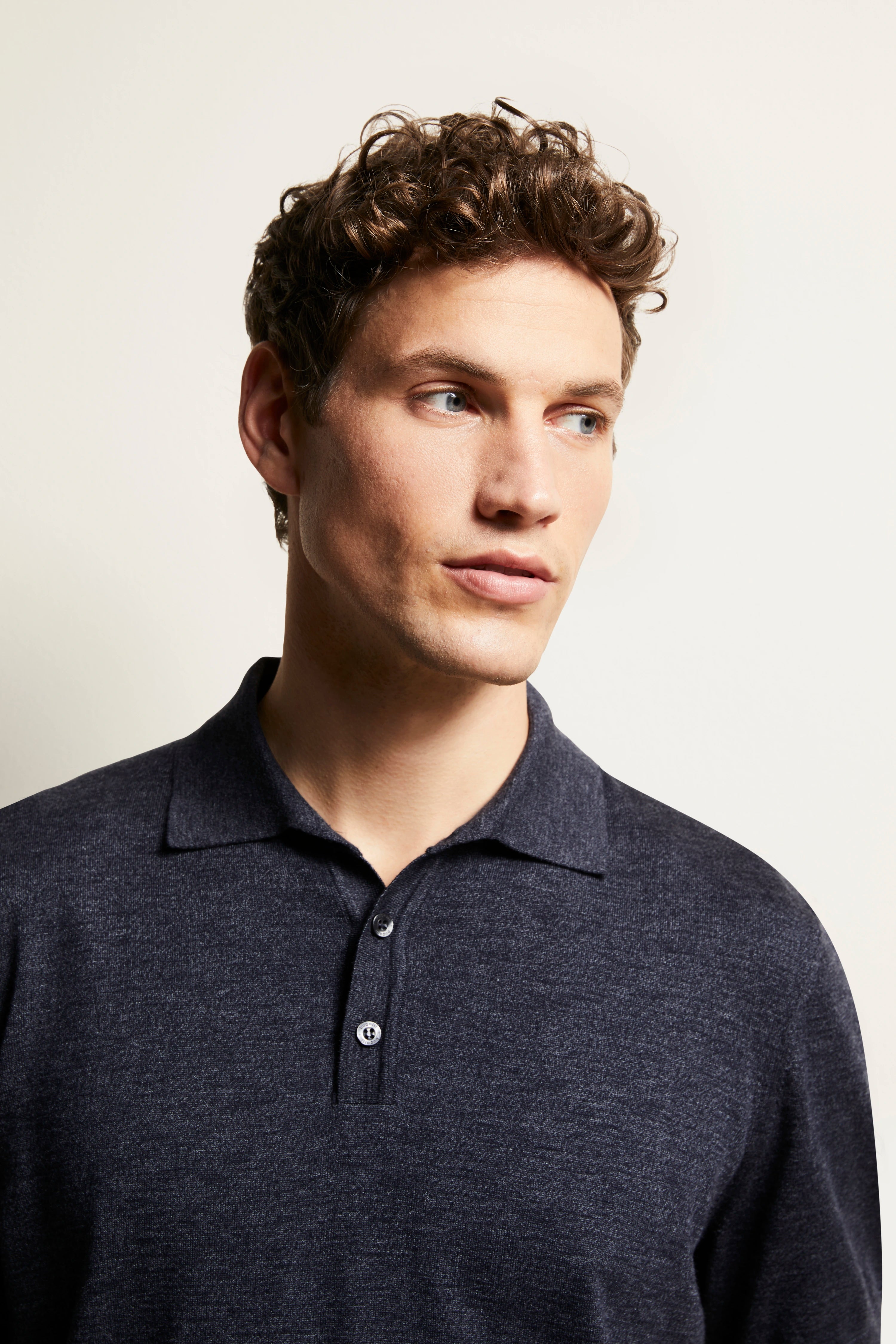 Model wears bugatti navy polo shirt, casual look, relaxed expression.