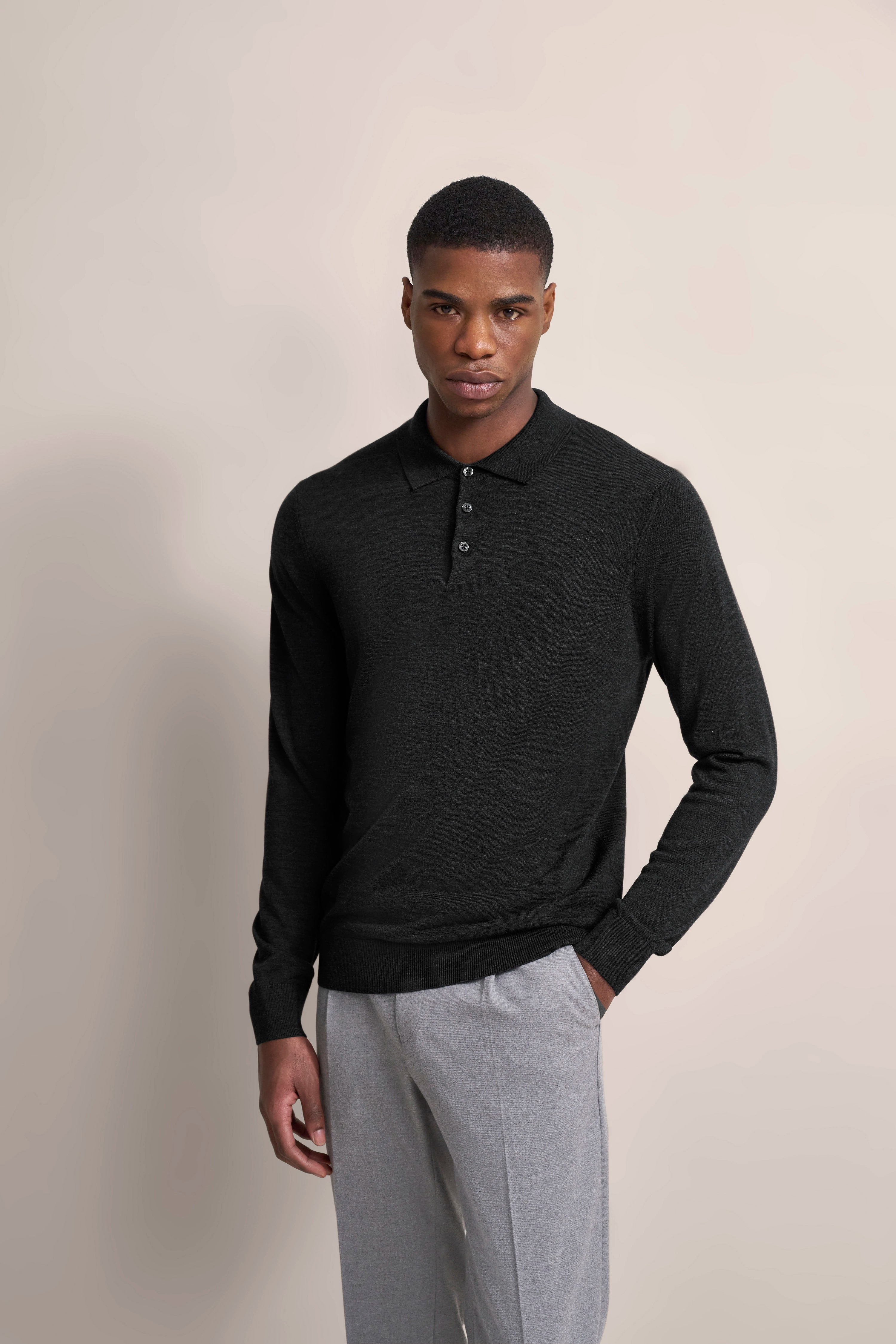 Black bugatti sweater, gray pants, model posing relaxed.