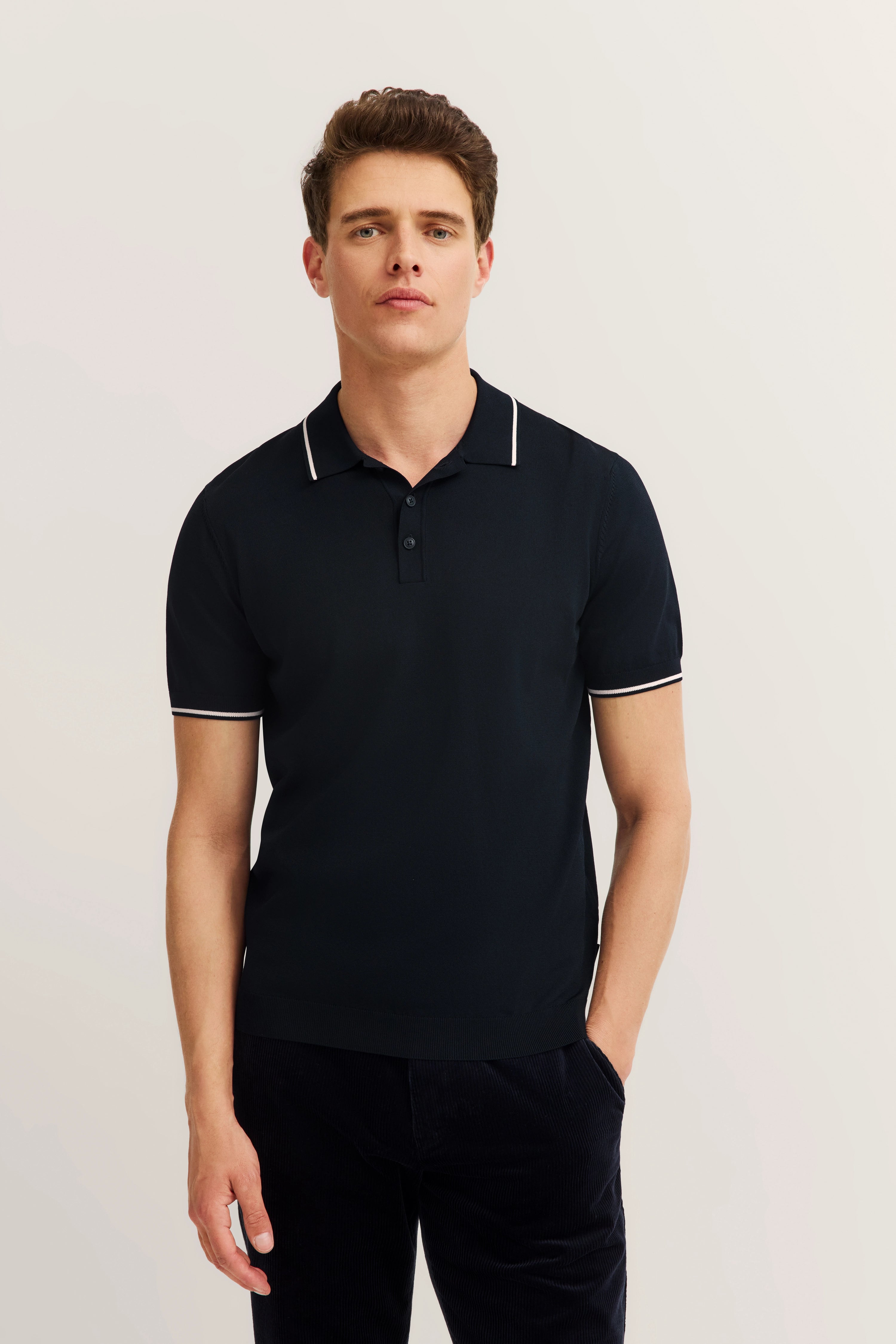 bugatti Polo in Schwarz, legeres Modelbild, entspannte Haltung, zeitlose Eleganz.