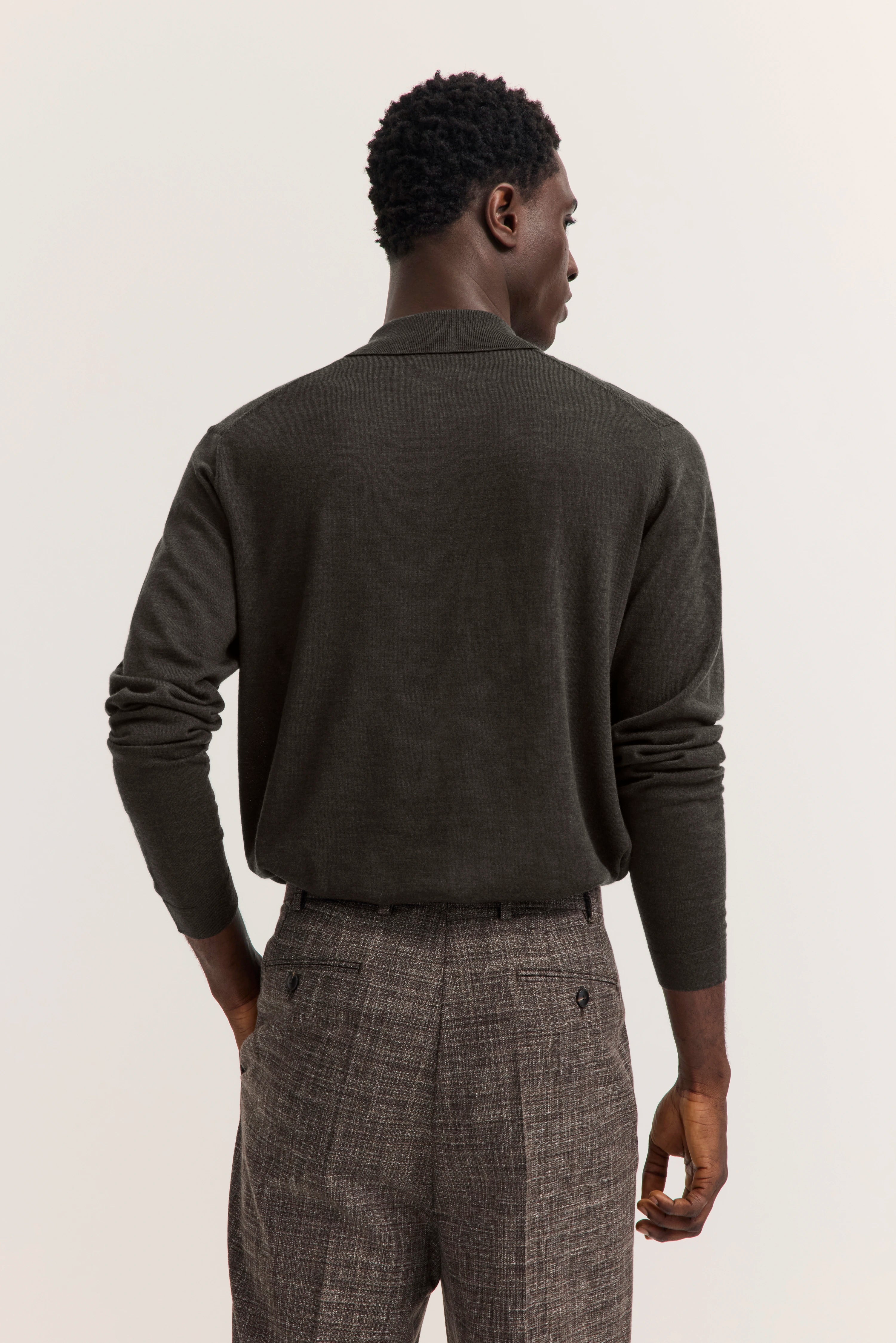 Model in dunkelgrauem Pullover und karierten Hosen von bugatti, Rückansicht, entspannte Pose.