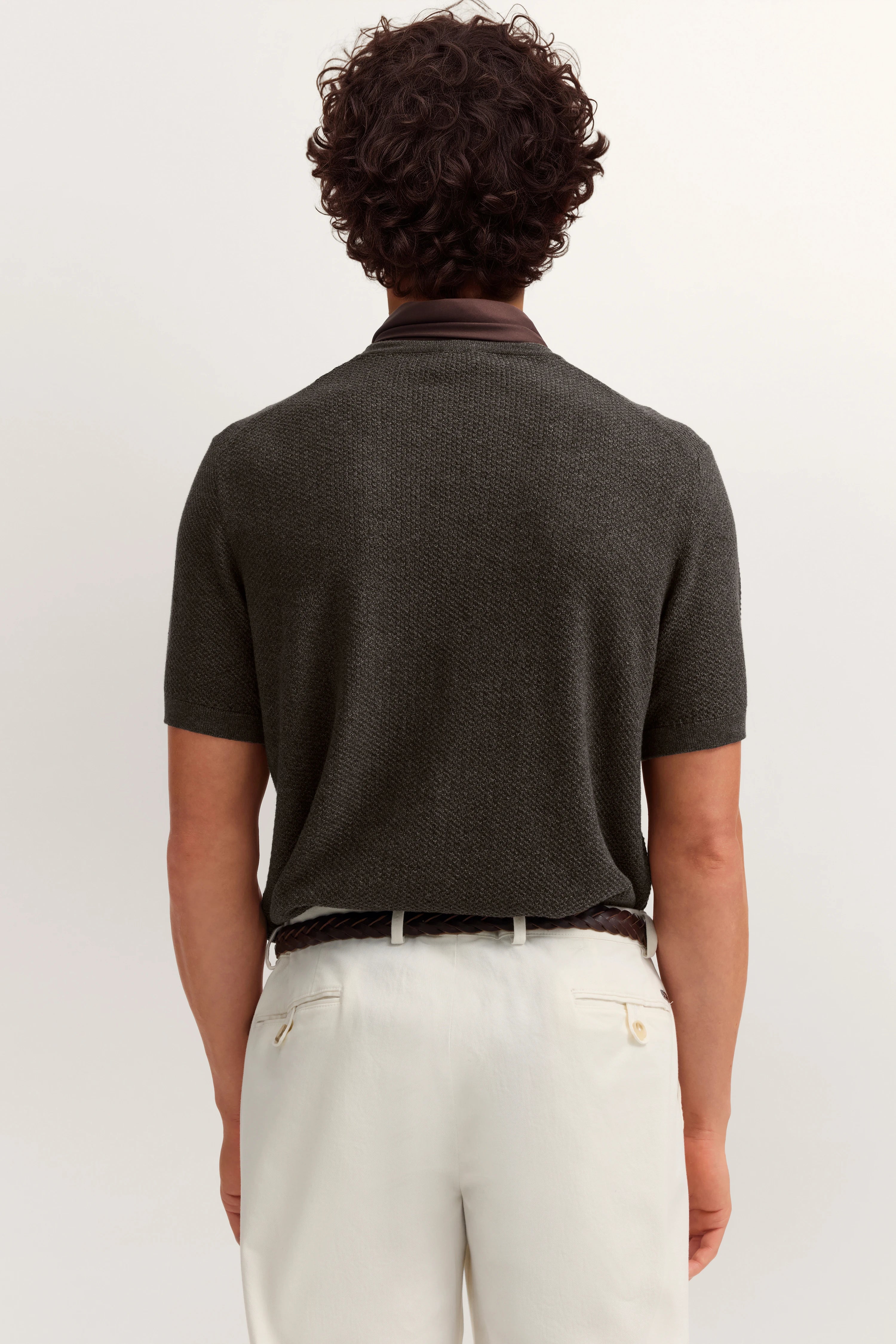 Dunkelgraues Polo von bugatti, weiße Hose, Rückenansicht, legeres Modelbild.