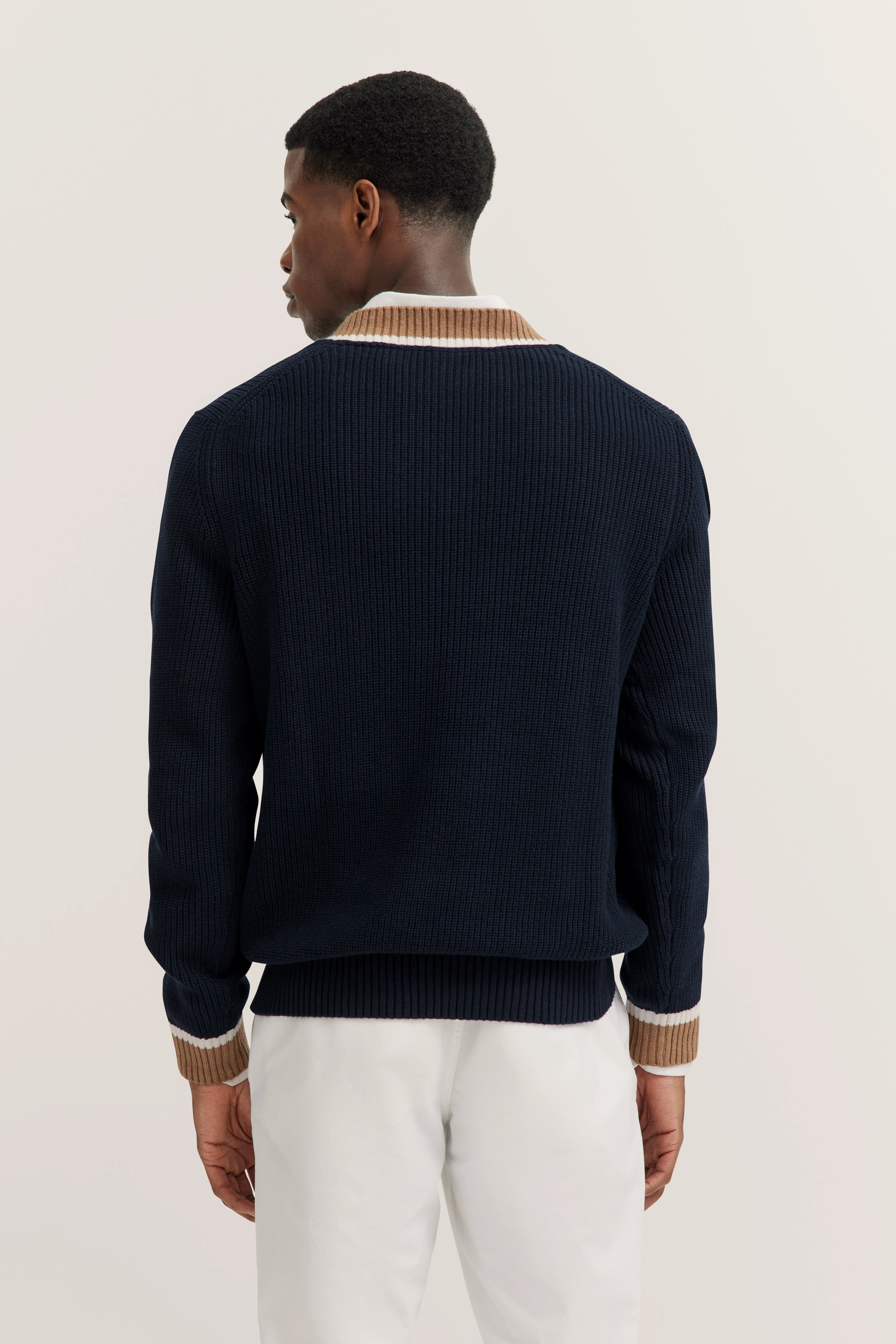 Dunkelblauer bugatti Pullover, beige Kragen, Modelbild, Rückansicht, lässige Pose.