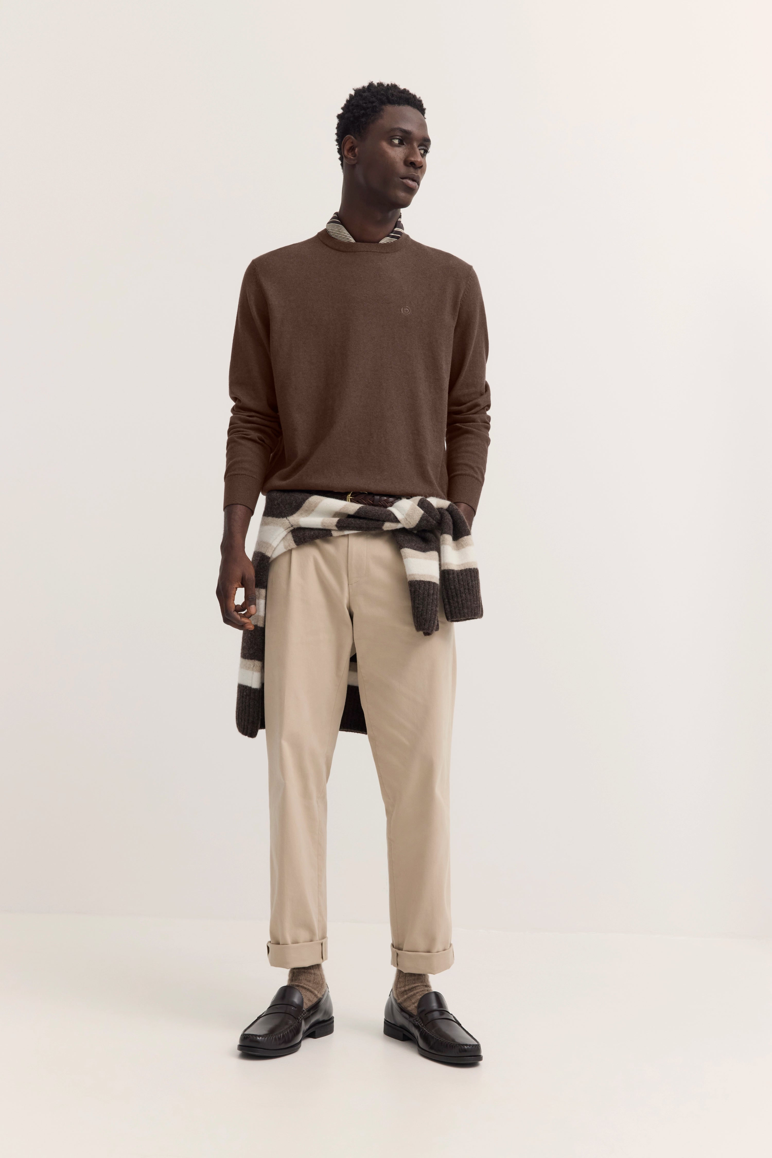 Elegant casual bugatti Outfit mit braunem Pullover, beige Chinos und gemusterter Strickjacke, legeres Modelposing.