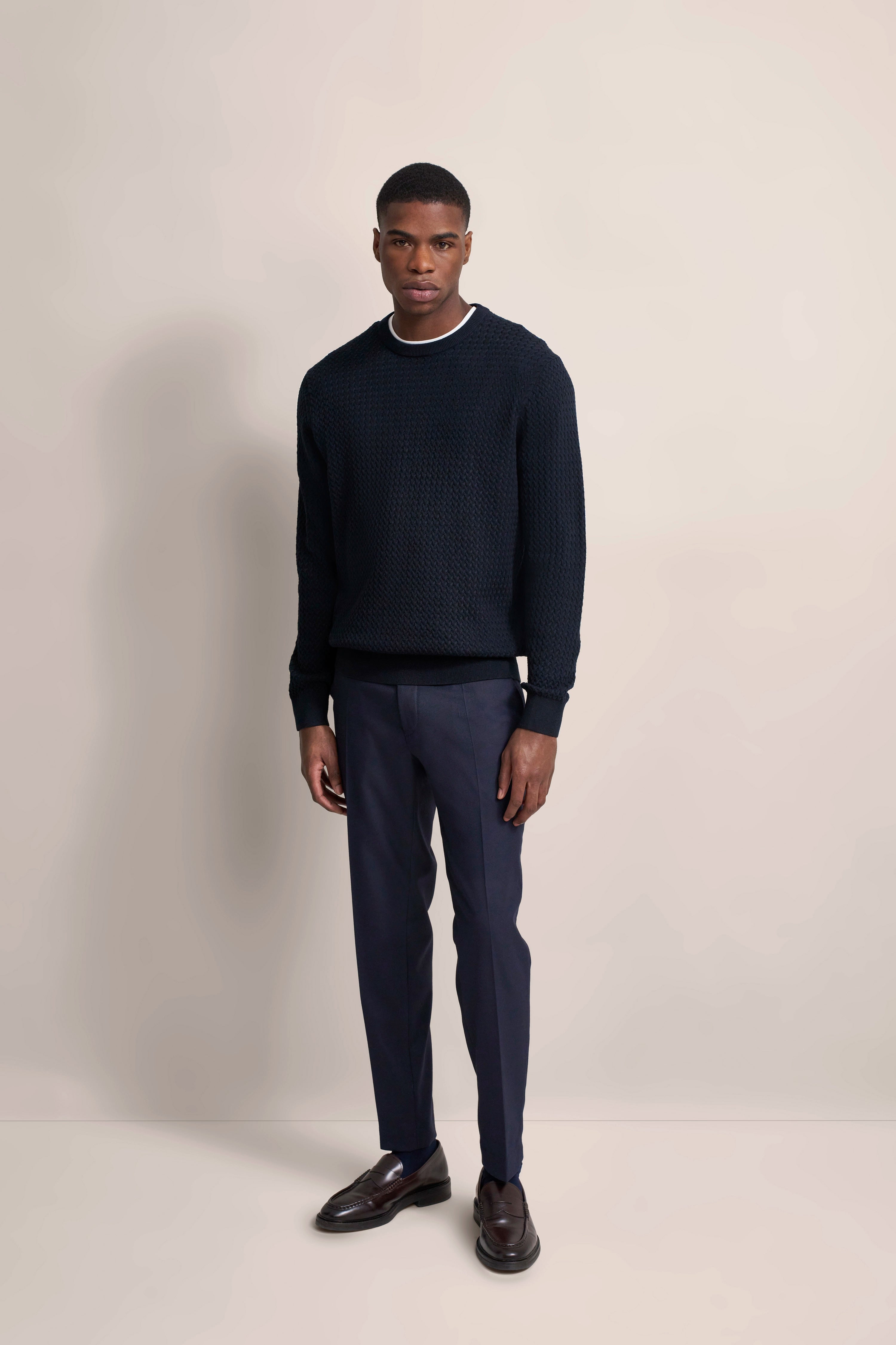 Model in dunkelblauem Pullover und Hose von bugatti, legerer Stand, stilvoll und klassisch.