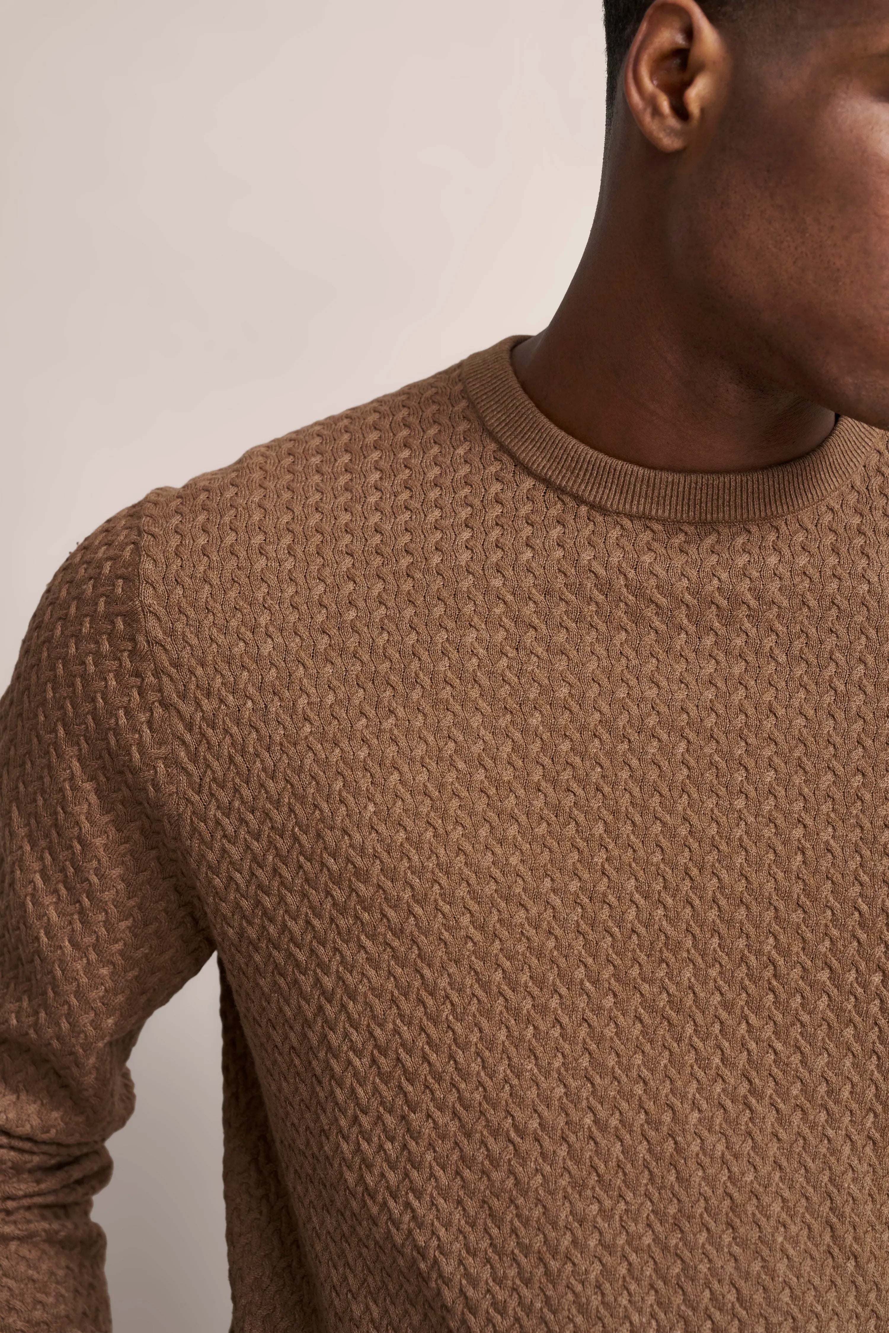 Brauner Strickpullover mit Zopfmuster als Büstenbild, bugatti Stil und Qualität.