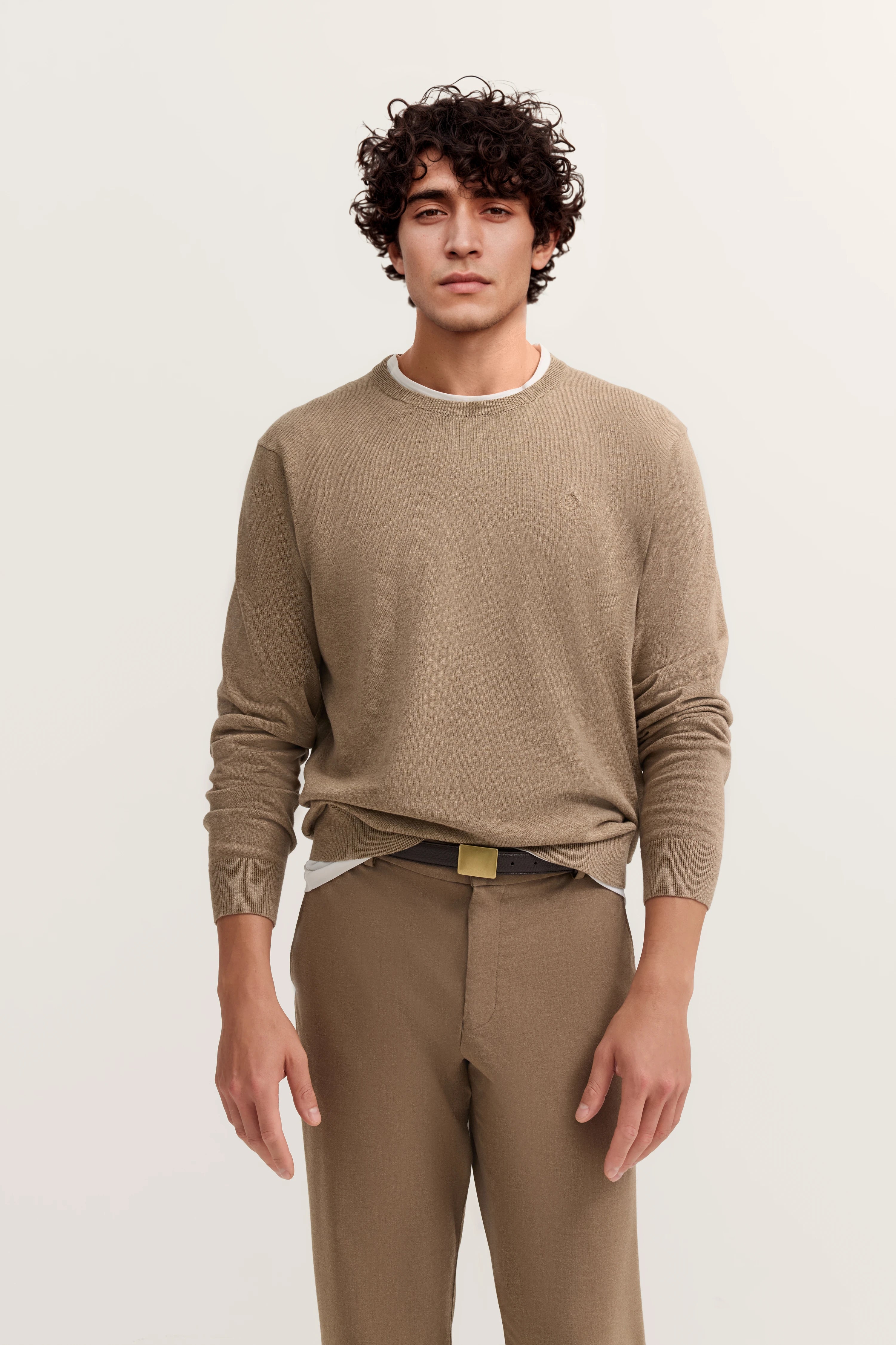 Beige bugatti Pullover und Hose, Modelbild, entspannte Pose.