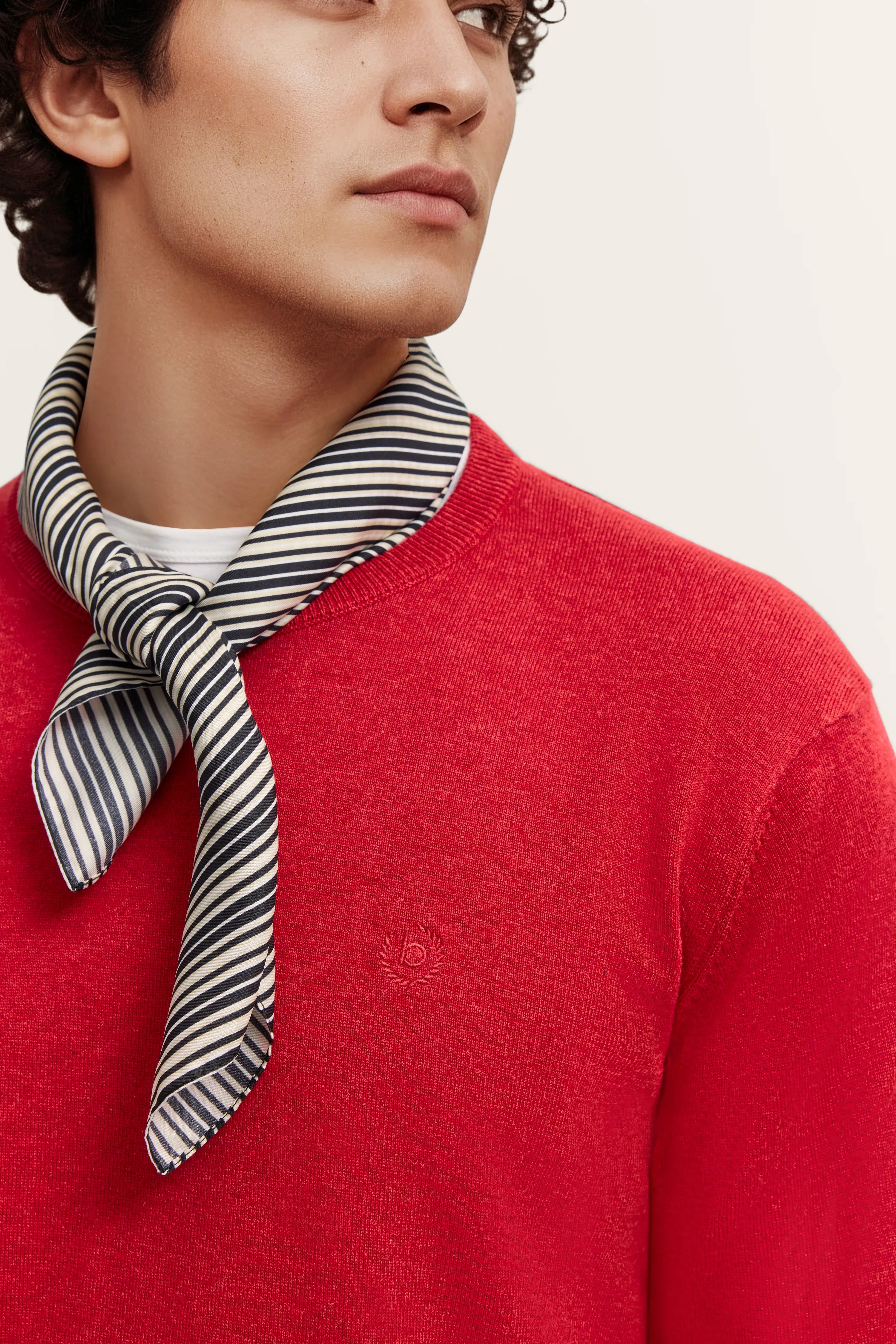 Rückenansicht: Roter bugatti Pullover, dunkle Jeans, Modelbild von hinten.