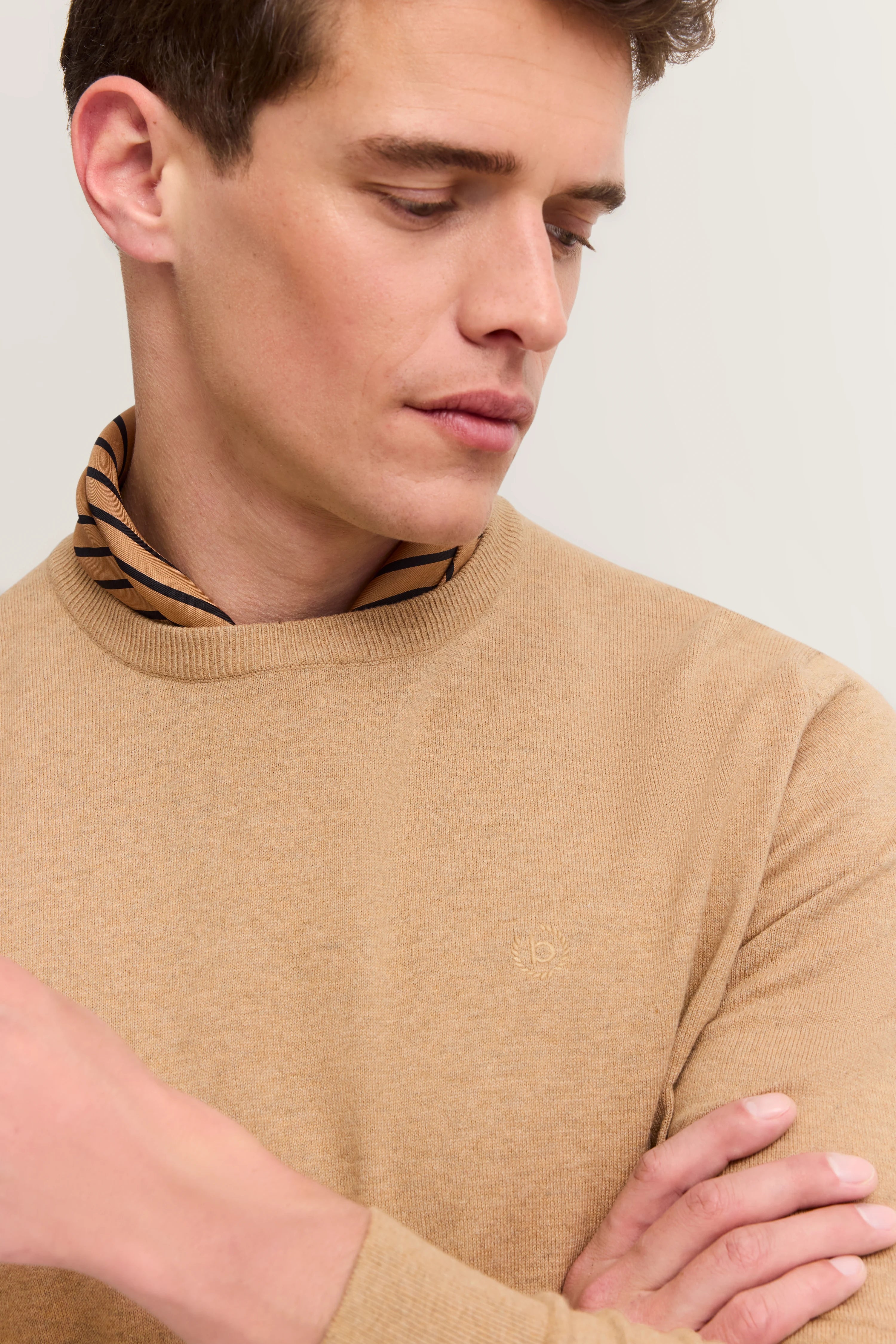 Modelbild mit camelbraunem bugatti Pullover und gestreiftem Kragen, legeres Posing, zeitloser Stil.