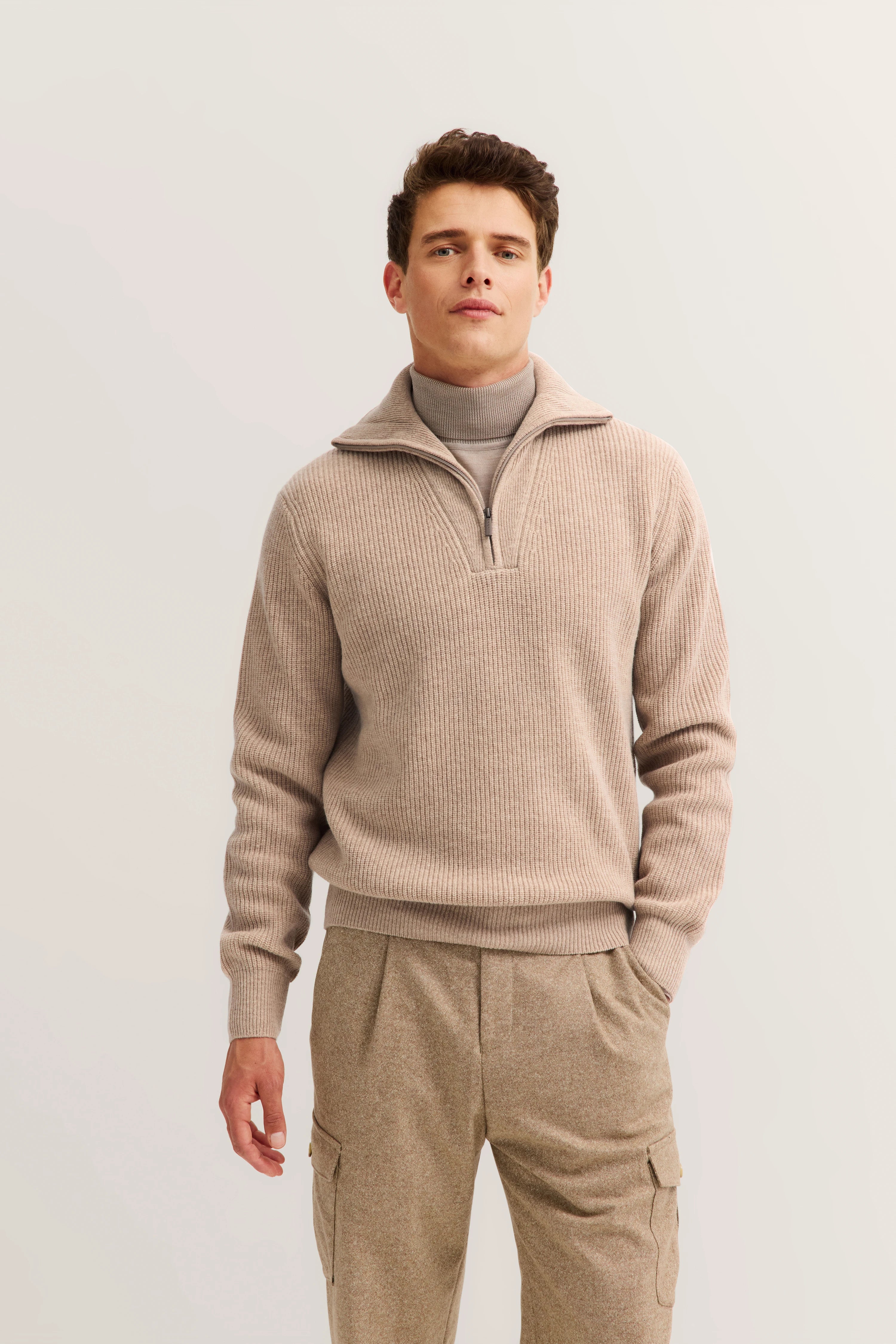 bugatti Model in beigem Strickpullover und passender Hose, entspanntes Posing.
