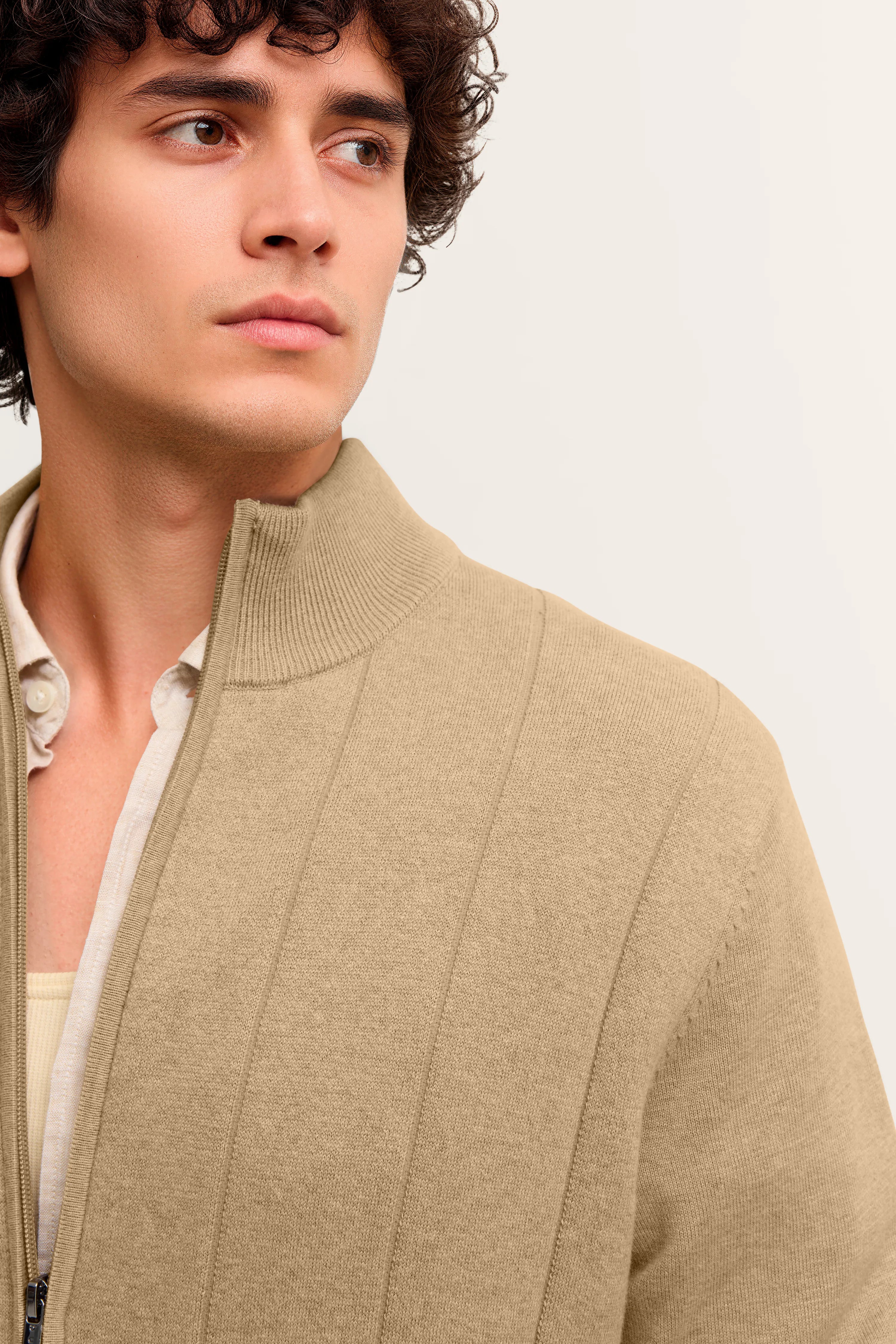 Beiges bugatti-Cardigan mit Reißverschluss über Hemd, legeres Modelbild, betont elegantes Design.