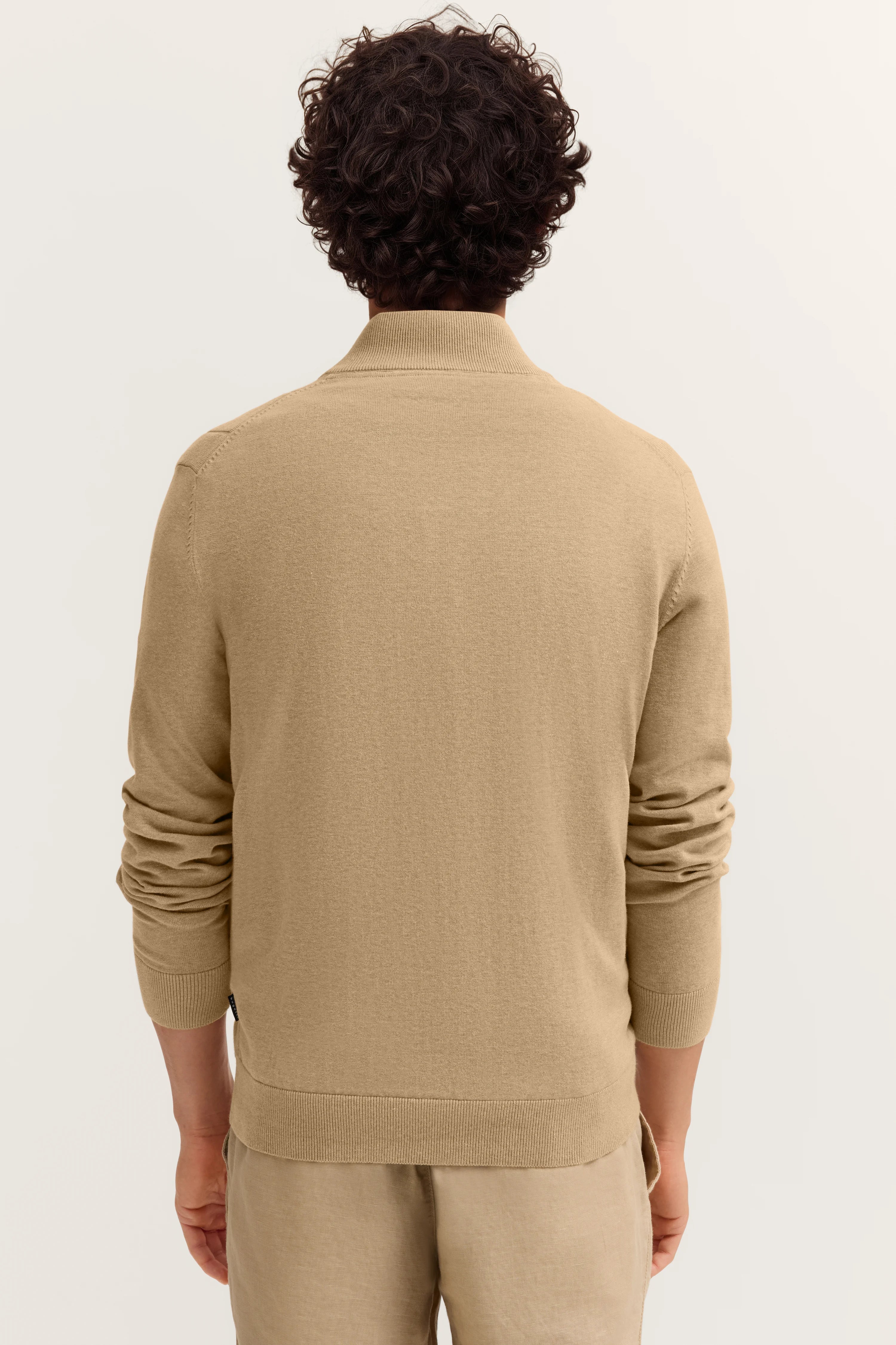 Beiger bugatti Pullover und Hose, Rückansicht, legeres Modelbild.