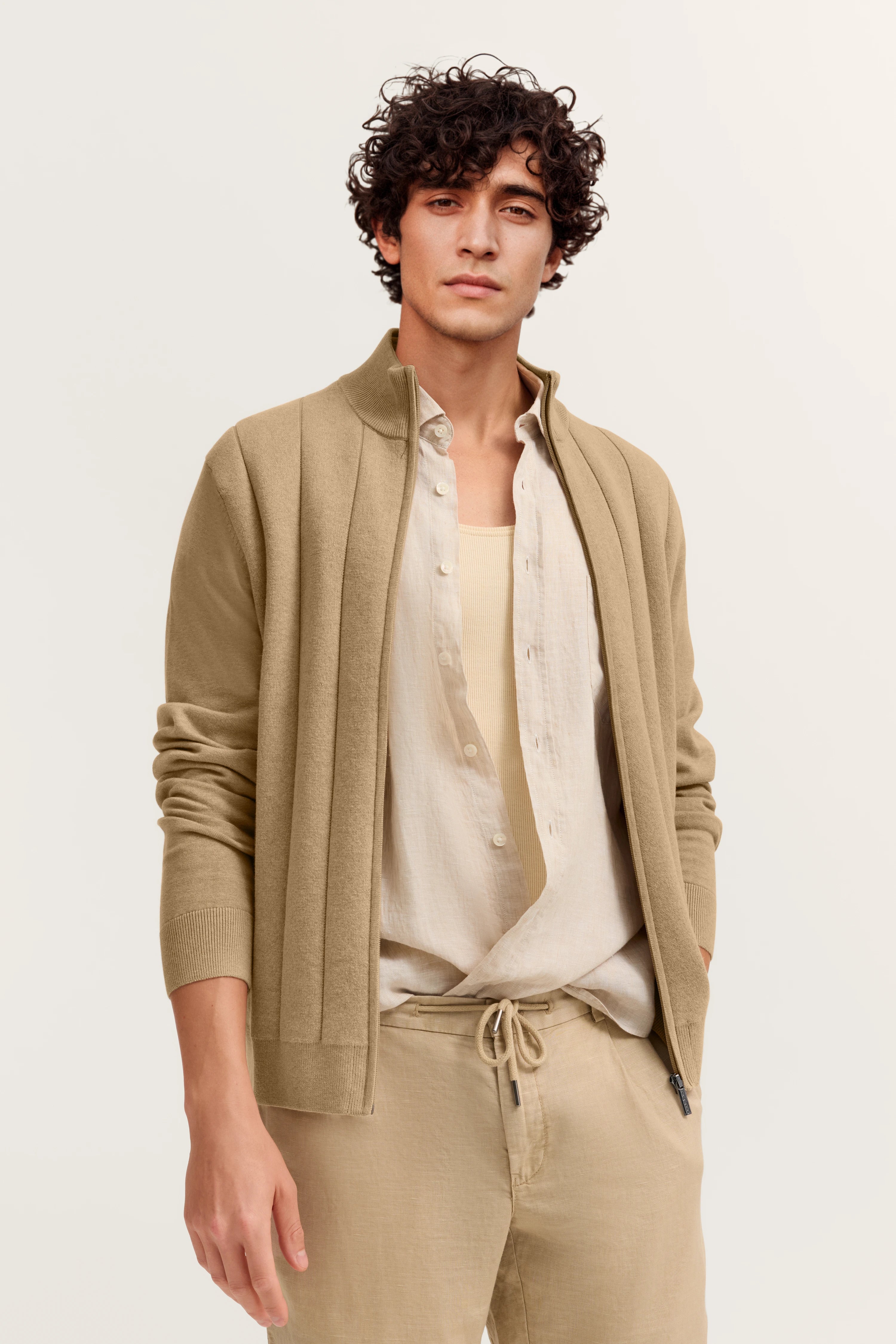 Beiges Model-Outfit von bugatti mit Jacke, Hemd und Hose. Lässiger Look mit natürlichem Posing.