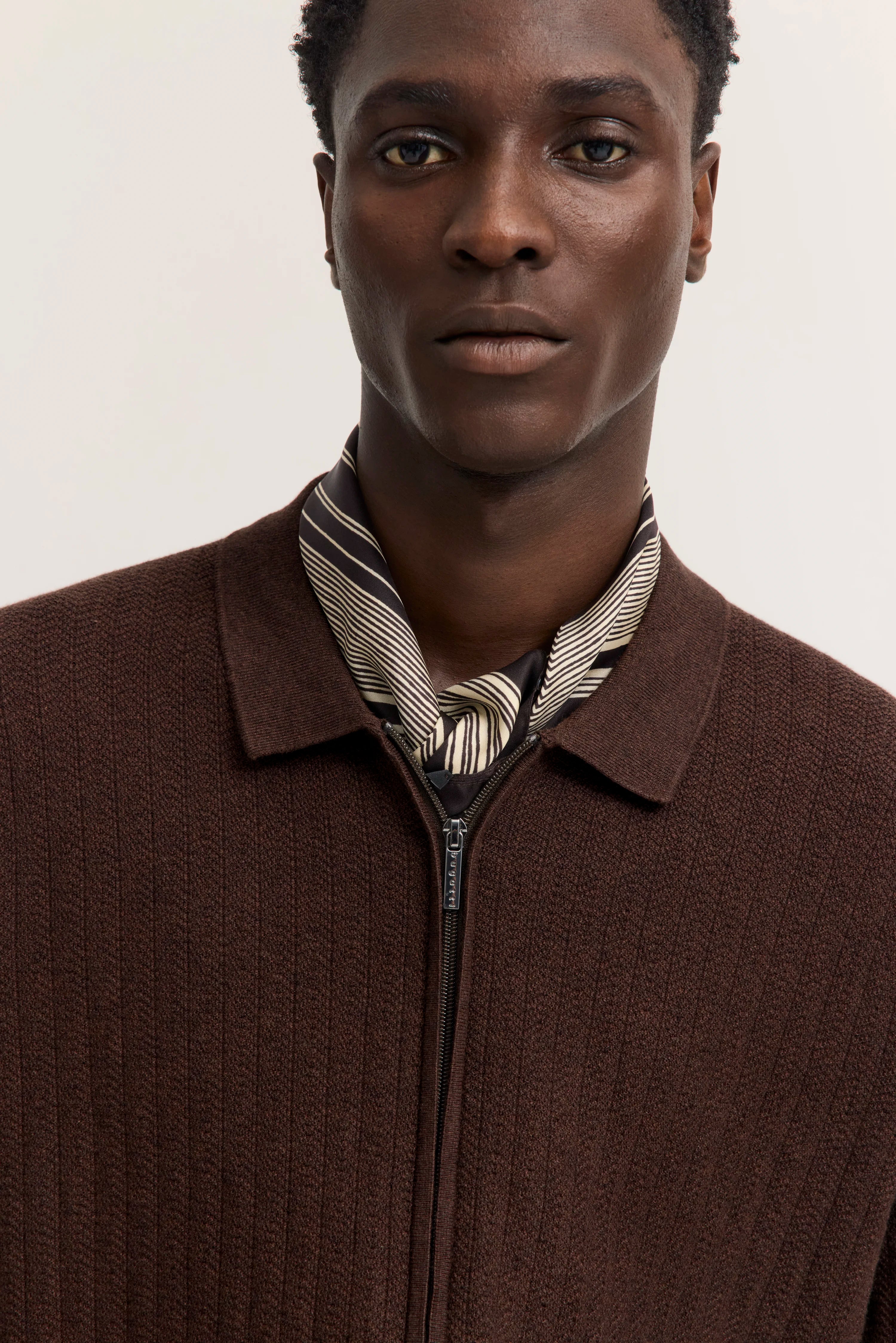 Brauner Pullover, graue Hose, Rückansicht, Modelbild.