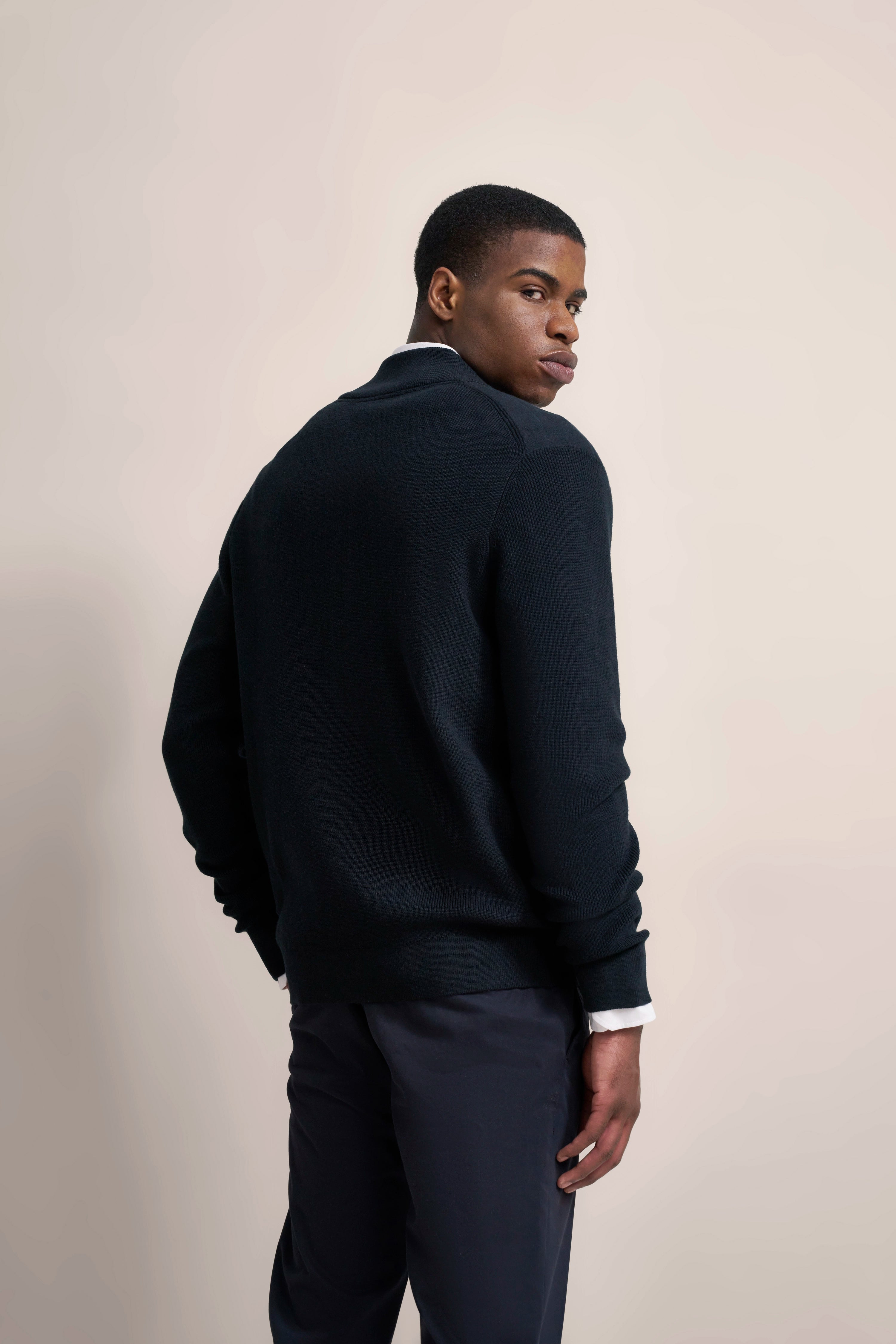 Model in dunklem bugatti Pullover und Hose, seitlich, elegantes Posing.