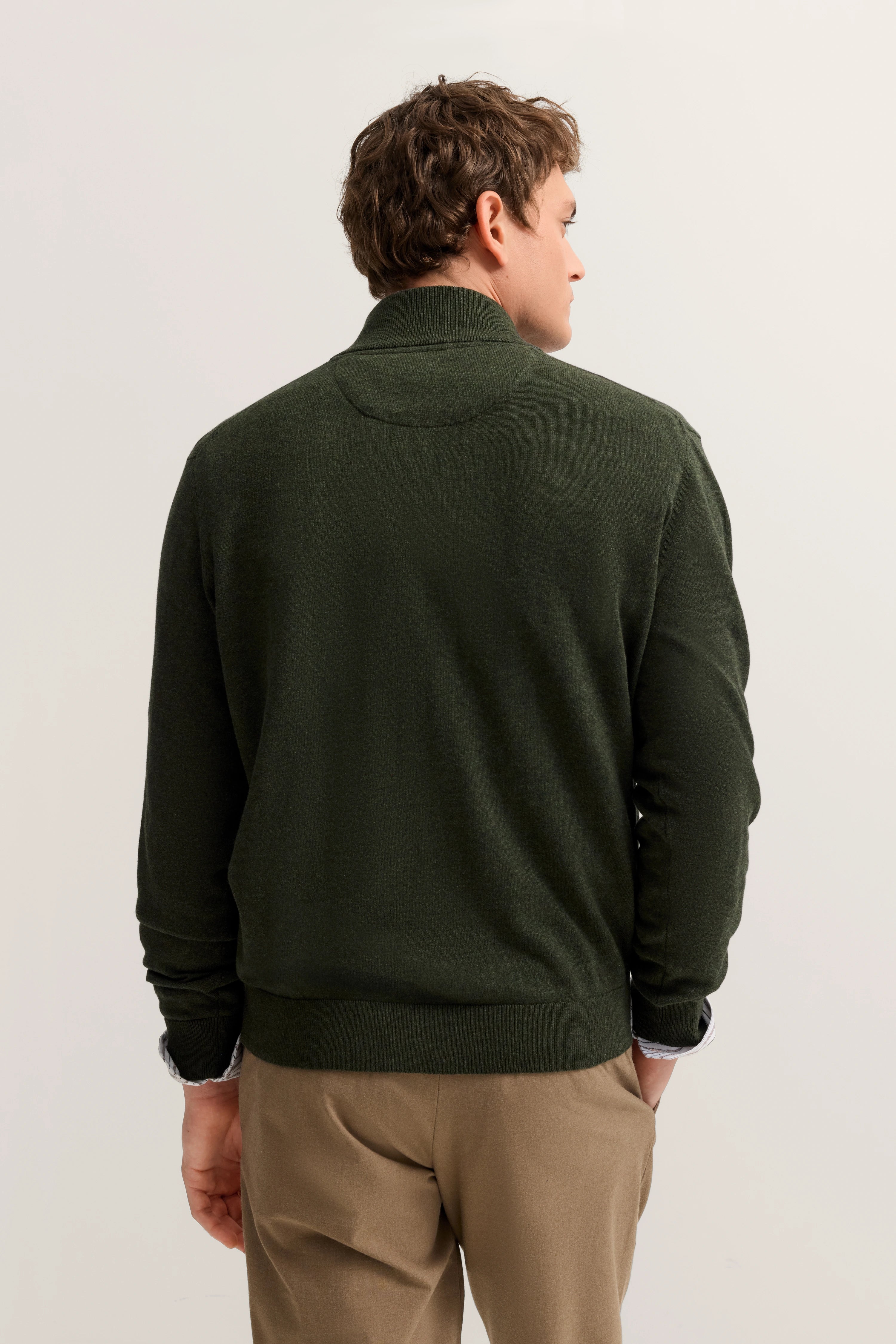 Grüner bugatti Pullover, Rückansicht, kombiniert mit beigen Hosen, legeres Modelbild.