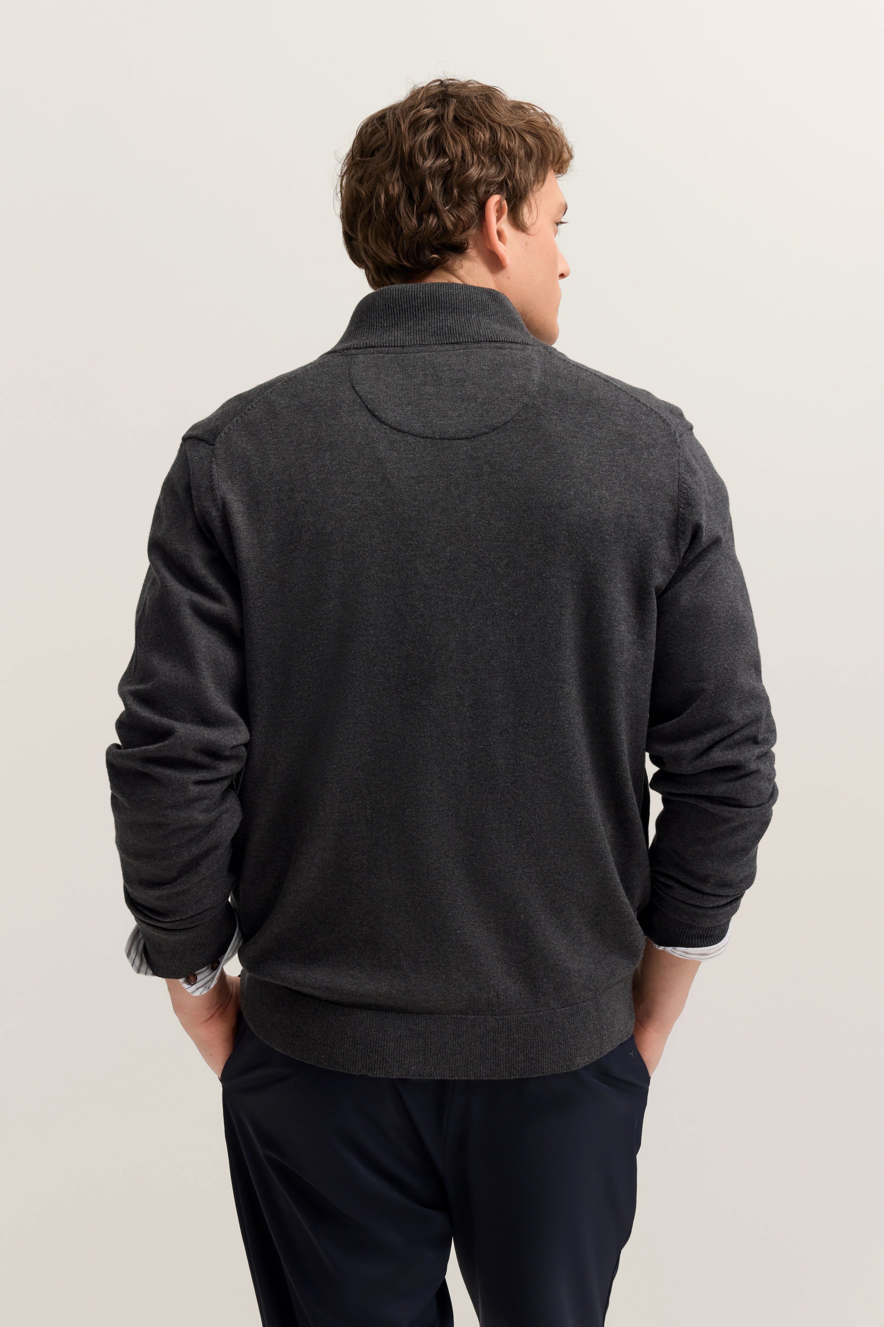 Grauer bugatti-Pullover, Rückansicht, legeres Modelbild, entspannte Haltung.