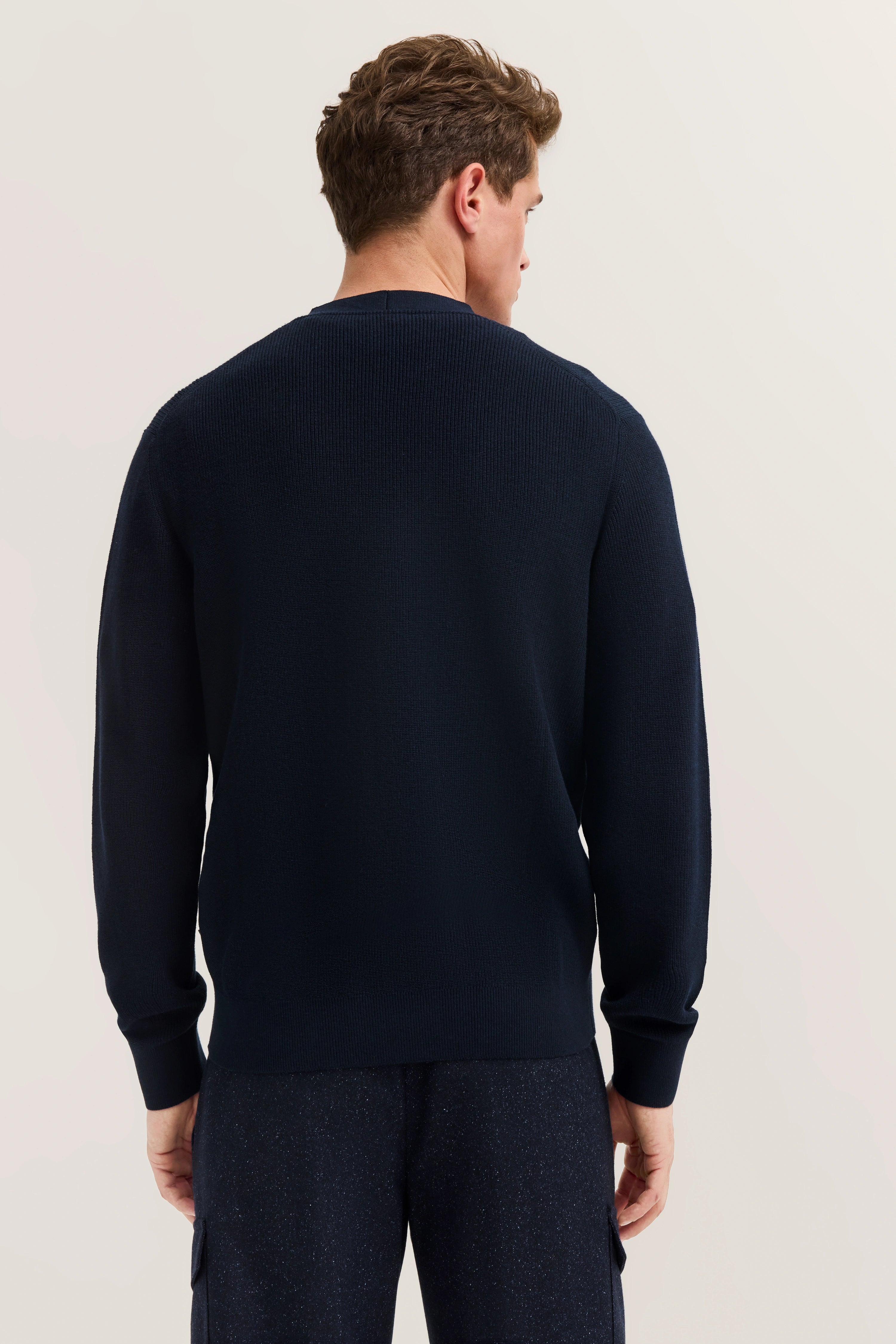 bugatti Pullover in Dunkelblau, Rückansicht auf Model, entspannte Pose. Eleganz und Komfort vereint.