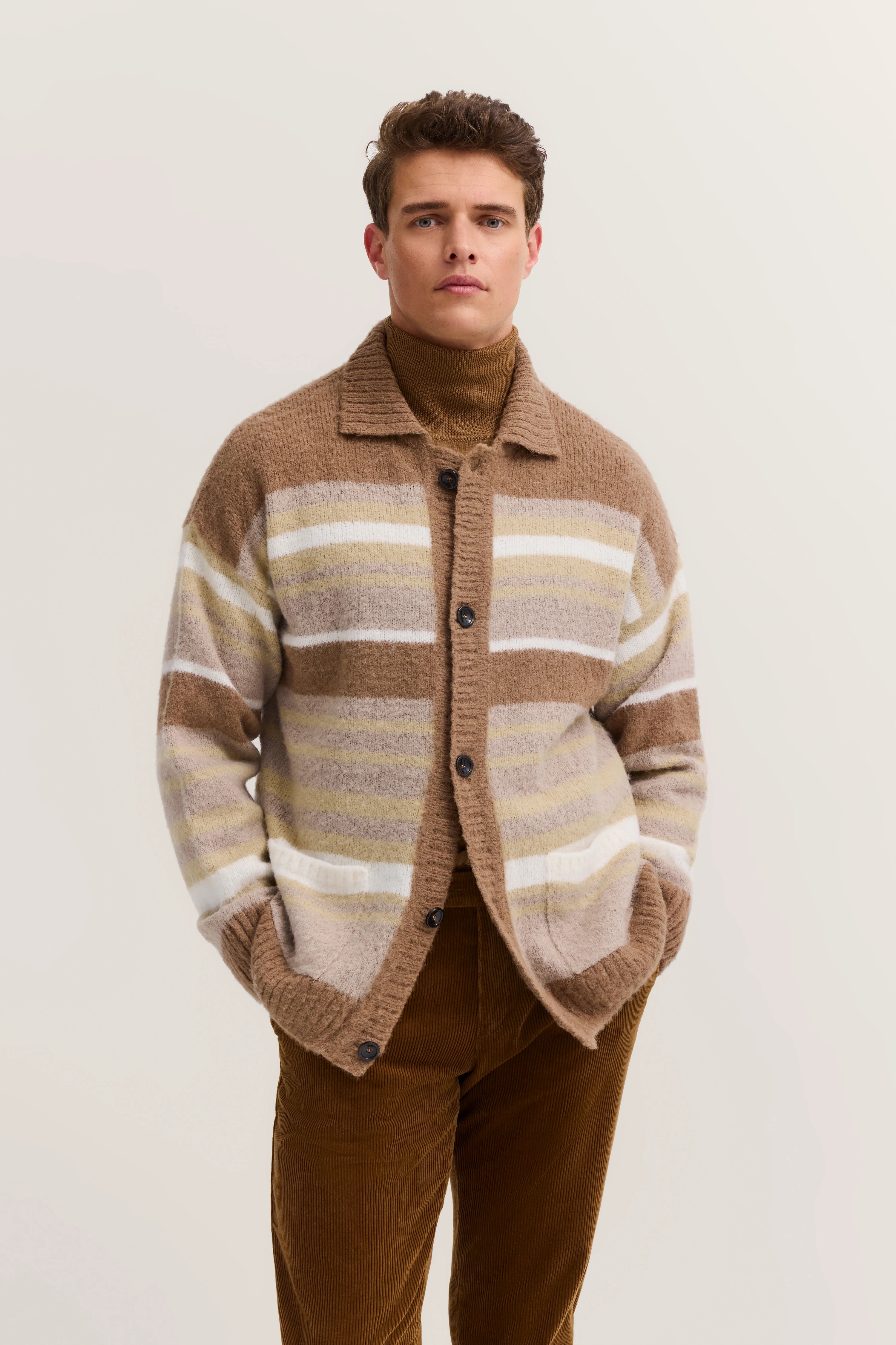 Striped beige and brown cardigan, model posing casually, embodying bugatti's refined Italian-inspired style.