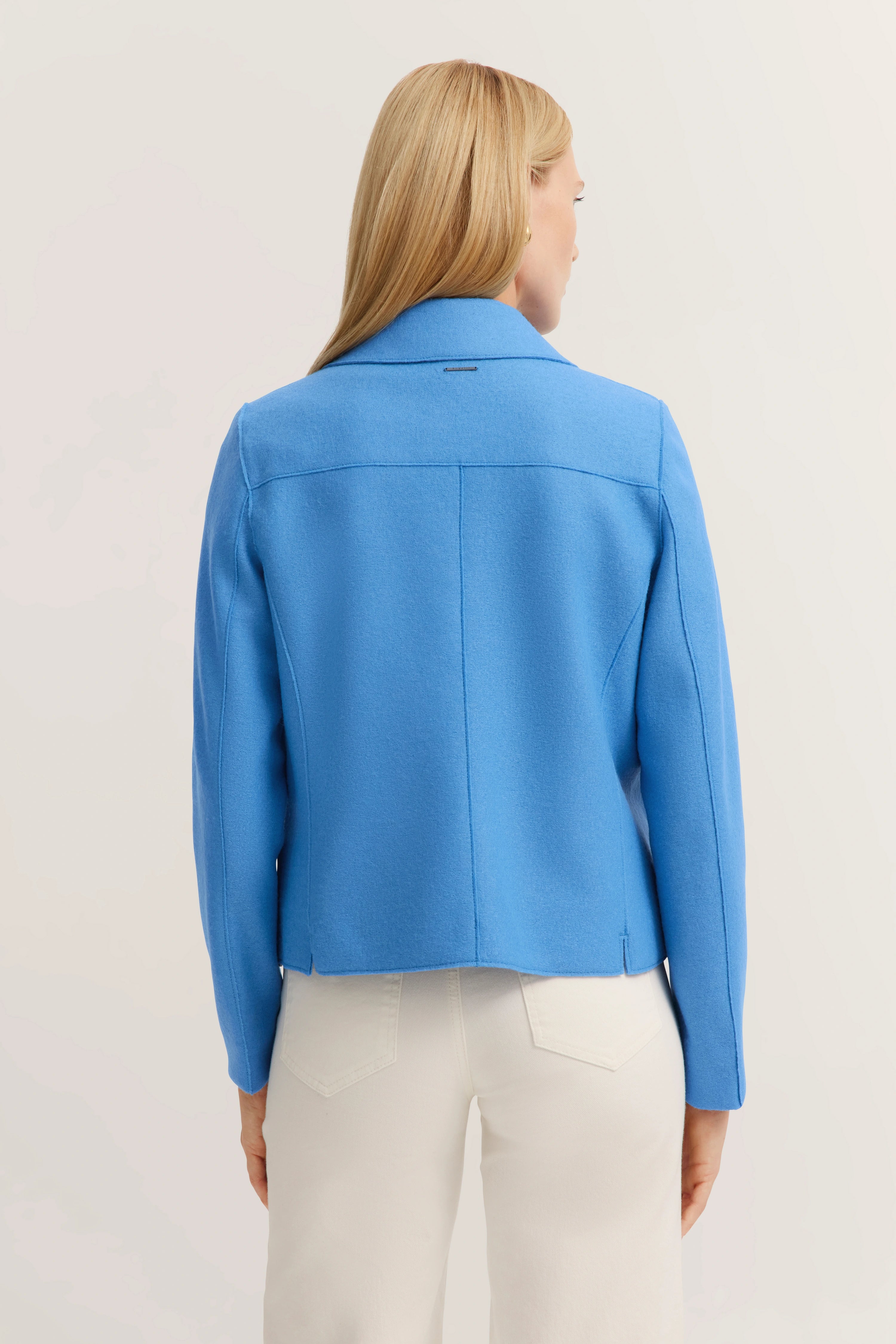 Blau bugatti colbert, achterkant, gecombineerd met witte broek, model toont rug.