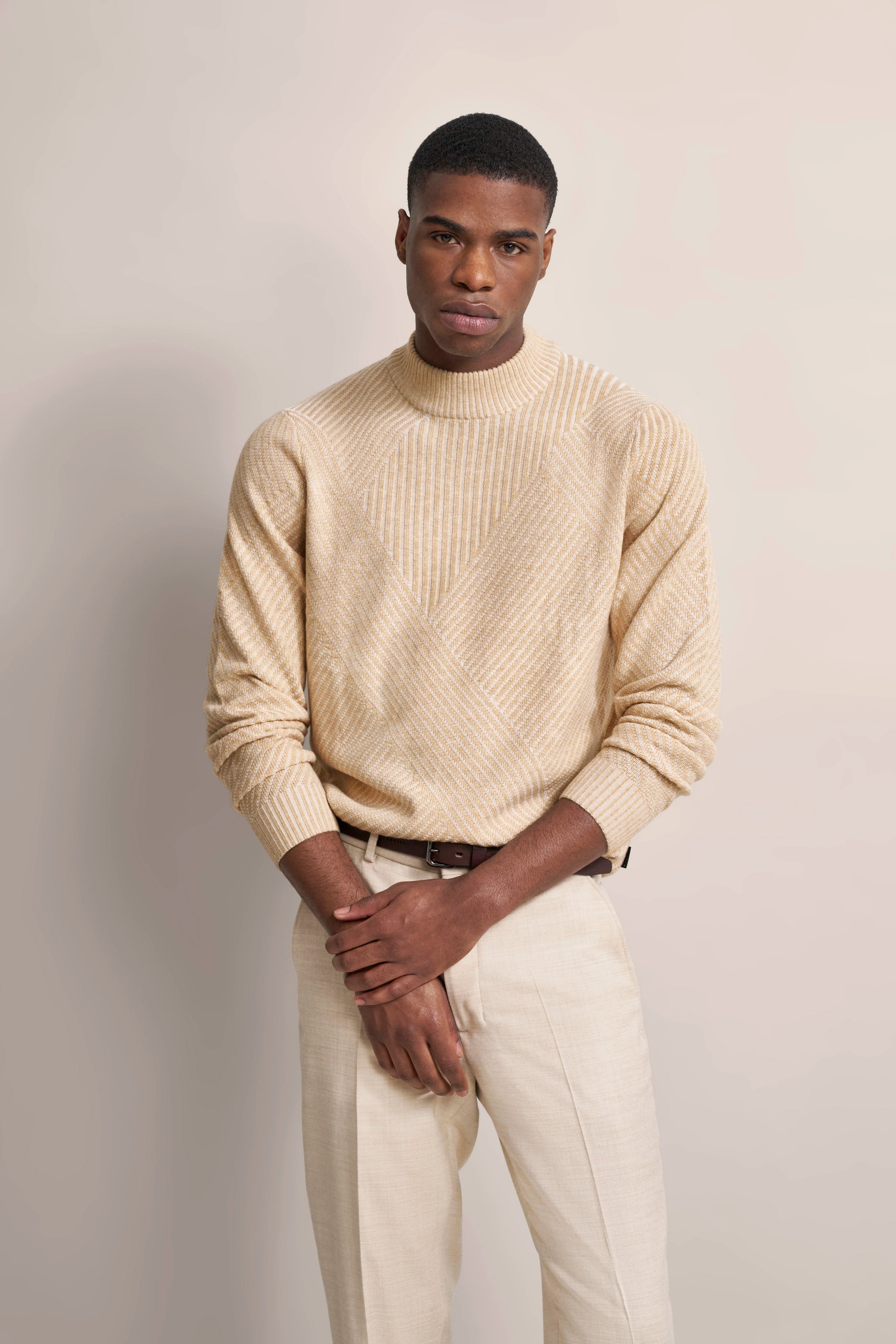 Modelbild: Beiges Strickpullover und Hose, lässige Pose, bugatti Stil.